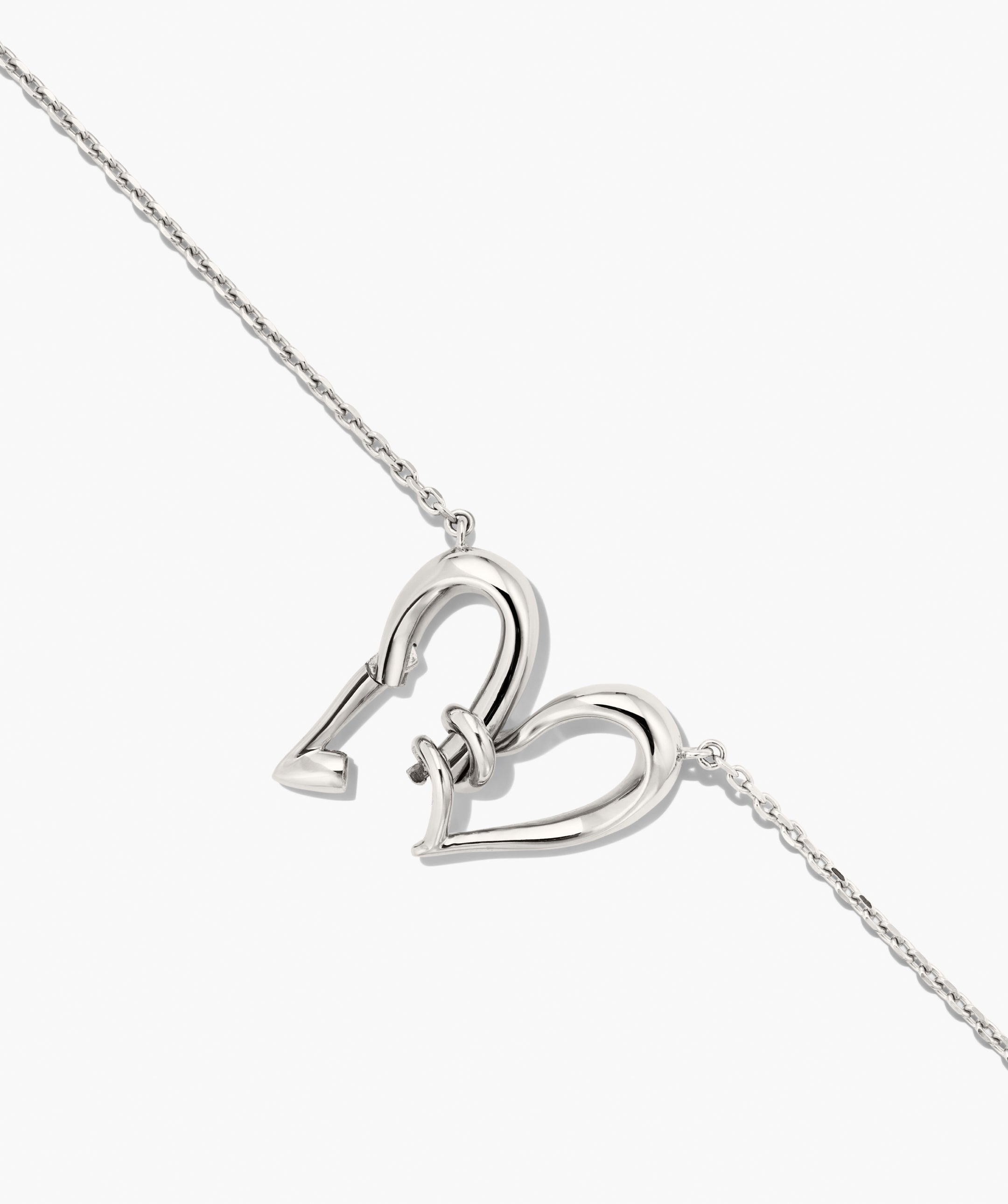 Heart to Heart Necklace featuring a fine silver-tone chain with an interlocking open-work heart toggle clasp, creating a modern, polished centerpiece.