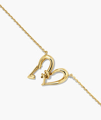 Heart to Heart Necklace featuring two interlocking heart-shaped links as the clasp, showcasing a modern twist on a classic design with sculptural drops.