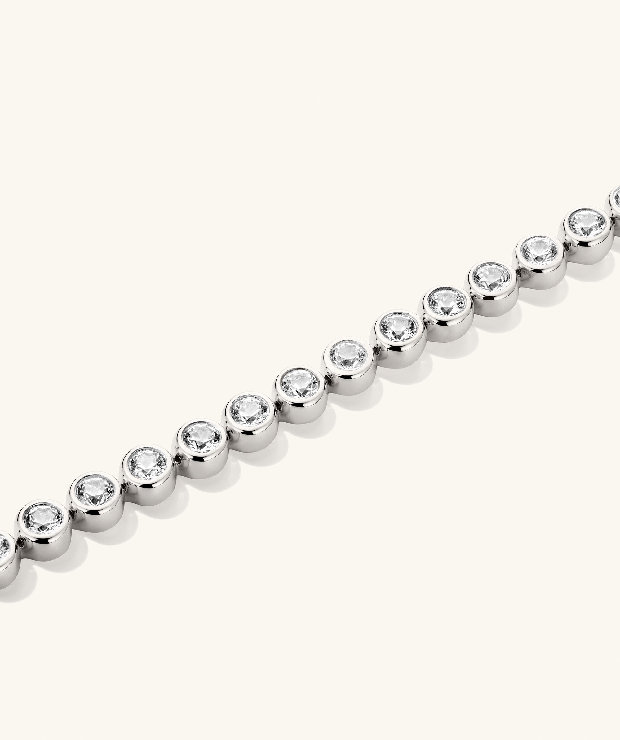 Zadie Bezel Lab Grown Sapphire Tennis Bracelet showcasing a silver chain adorned with diamonds in a bezel setting, highlighting its refined elegance and shine.