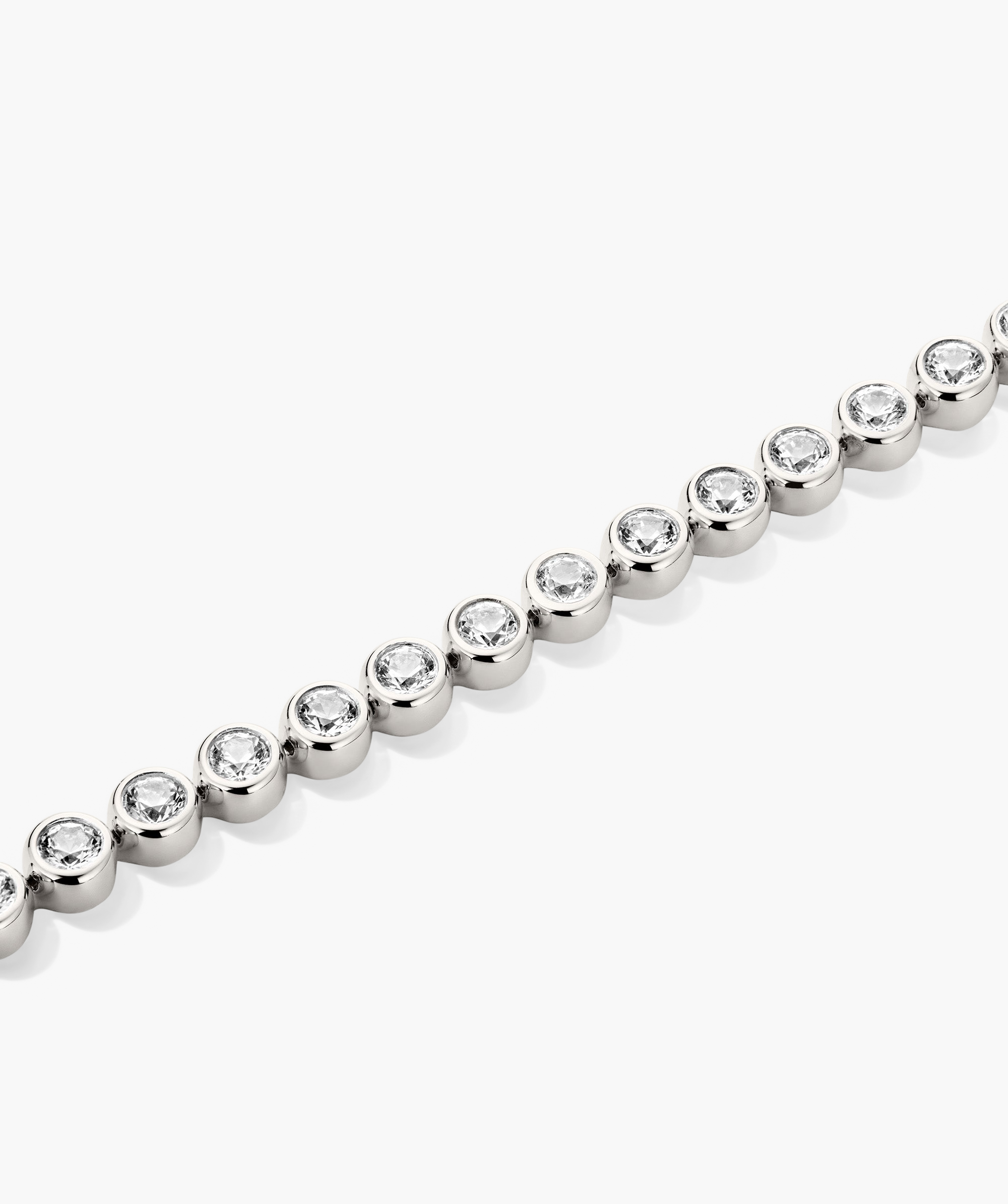 Zadie Bezel Lab Grown Sapphire Tennis Bracelet showcasing a silver chain adorned with diamonds in a bezel setting, highlighting its refined elegance and shine.
