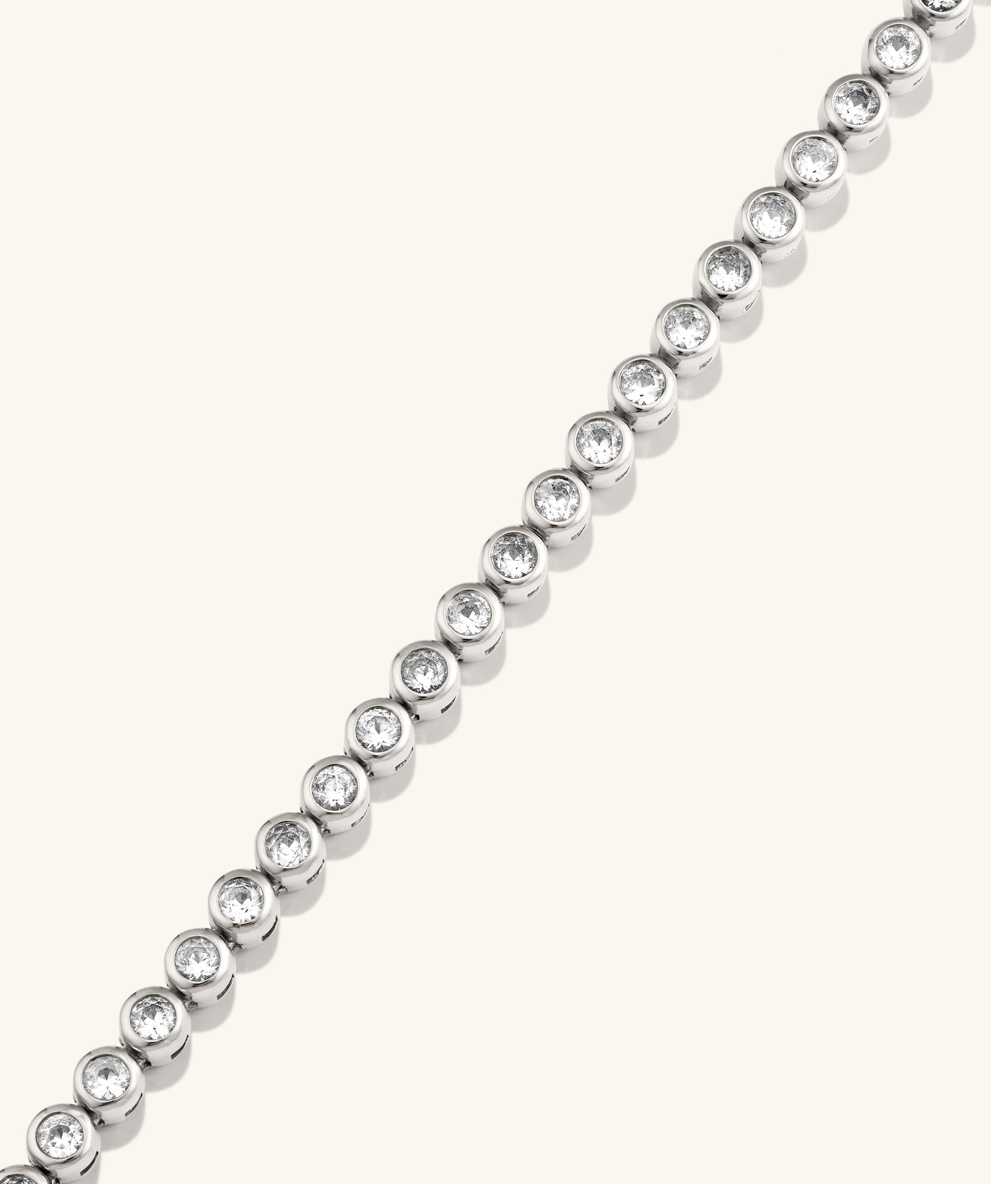 Zadie Bezel Lab Grown Sapphire Tennis Necklace featuring a silver chain with diamond accents, showcasing its elegant metalwork and fashion-forward design.