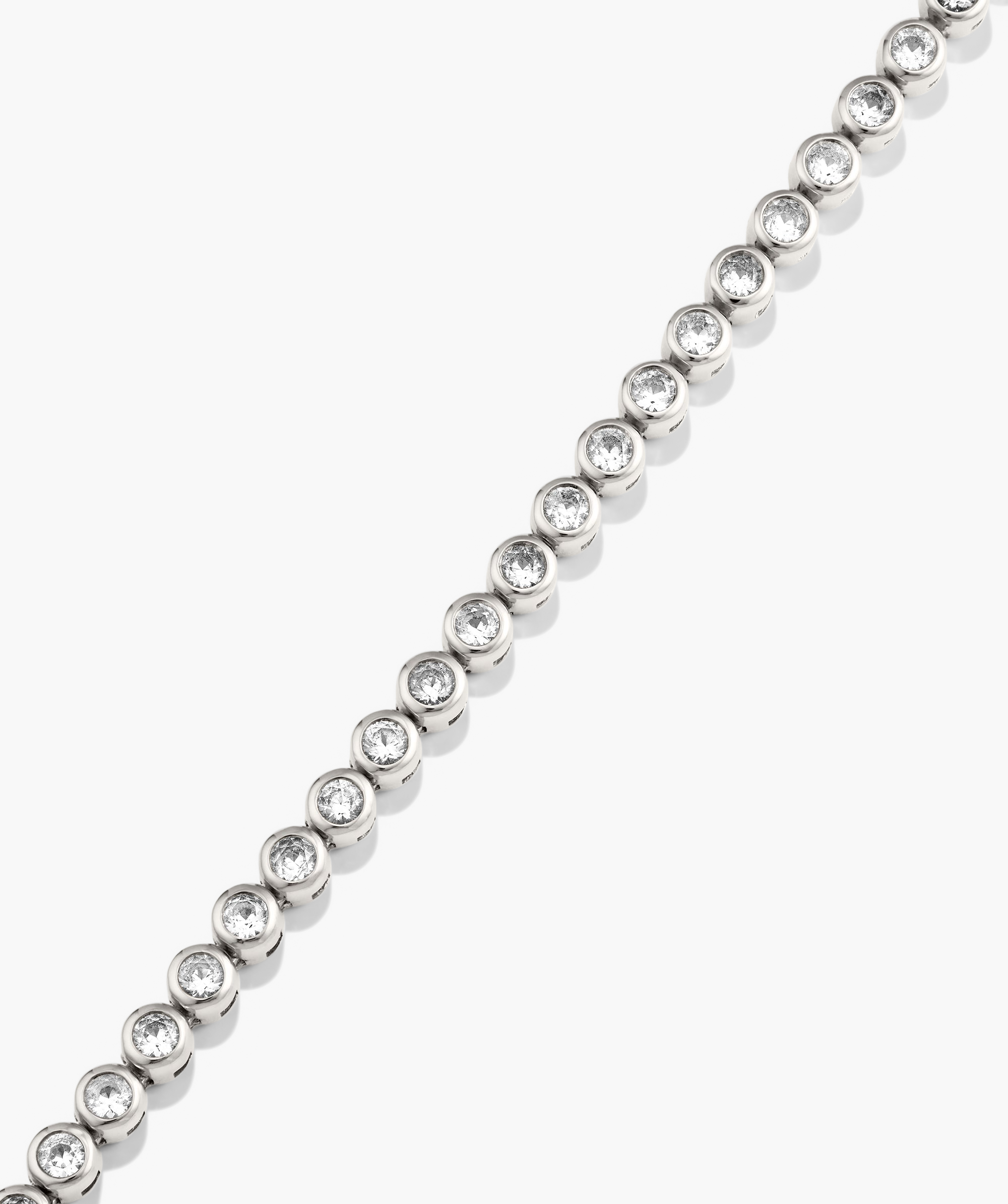 Zadie Bezel Lab Grown Sapphire Tennis Necklace featuring a silver chain with diamond accents, showcasing its elegant metalwork and fashion-forward design.