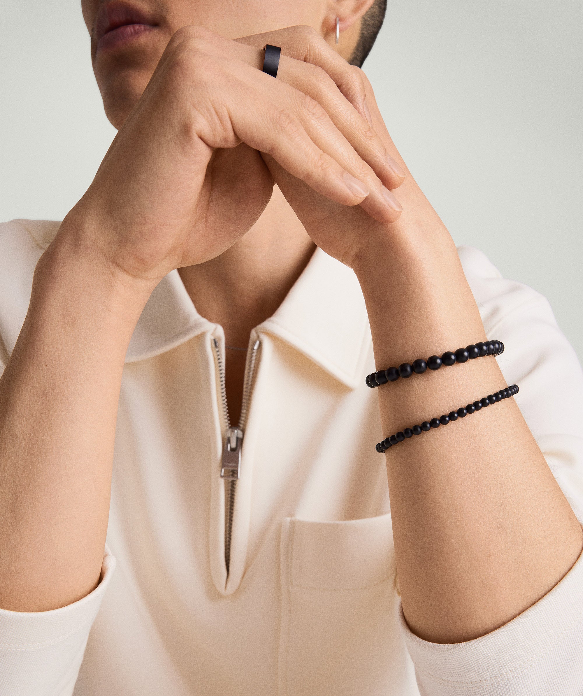 Person wearing a white shirt showcasing a 6mm Gemstone Beaded Bracelet in sterling silver with a swivel clasp on their wrist.