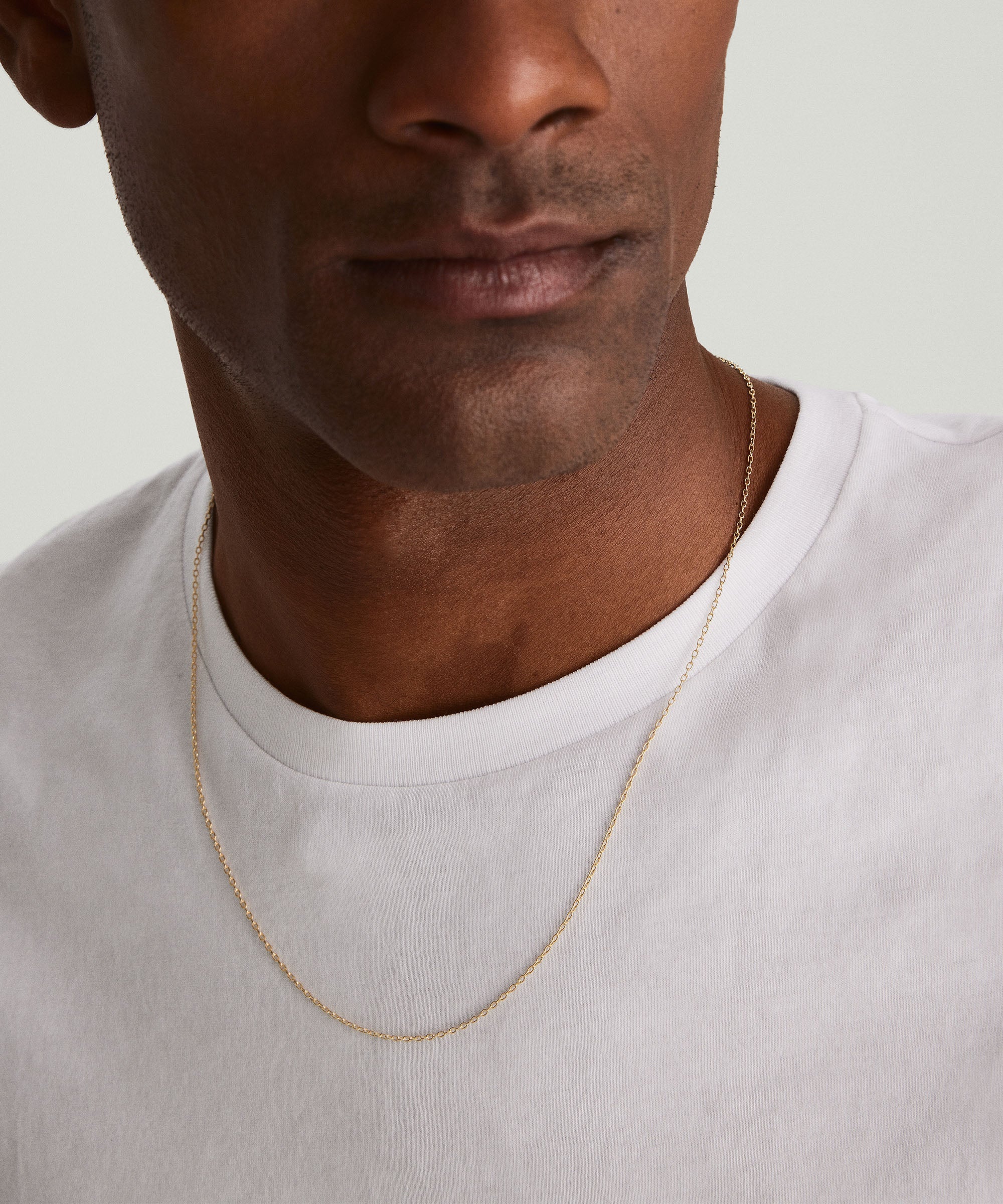 Man wearing a white shirt and a Cable Chain Necklace, showcasing the handcrafted 14k solid yellow gold design.