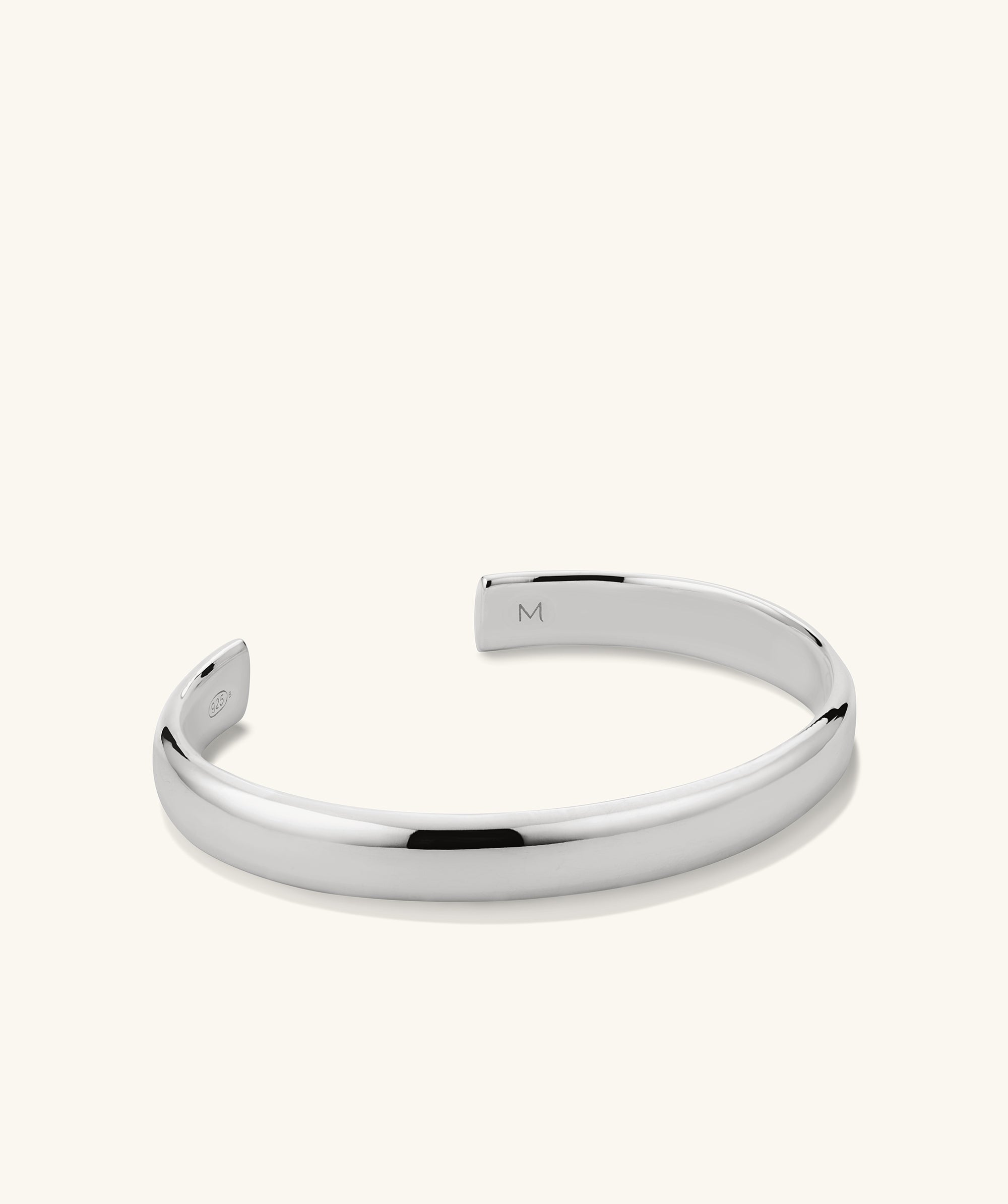 Silver Bold Cuff bracelet featuring a sleek design with a letter 'M' charm, ideal for versatile wear.
