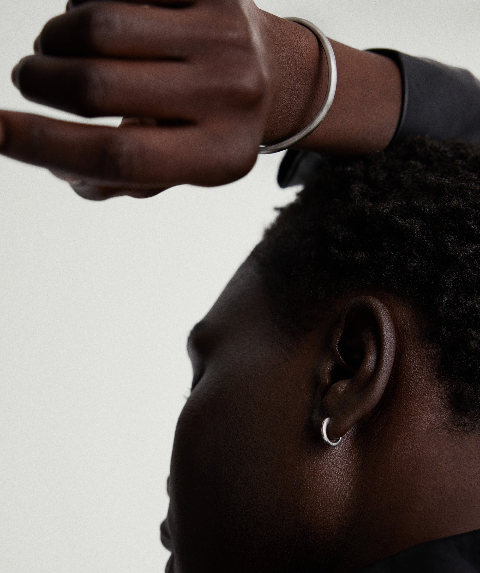 A close-up of a wrist adorned with the Slim Cuff, a sleek silver bracelet, showcasing its minimalist design suitable for any occasion.