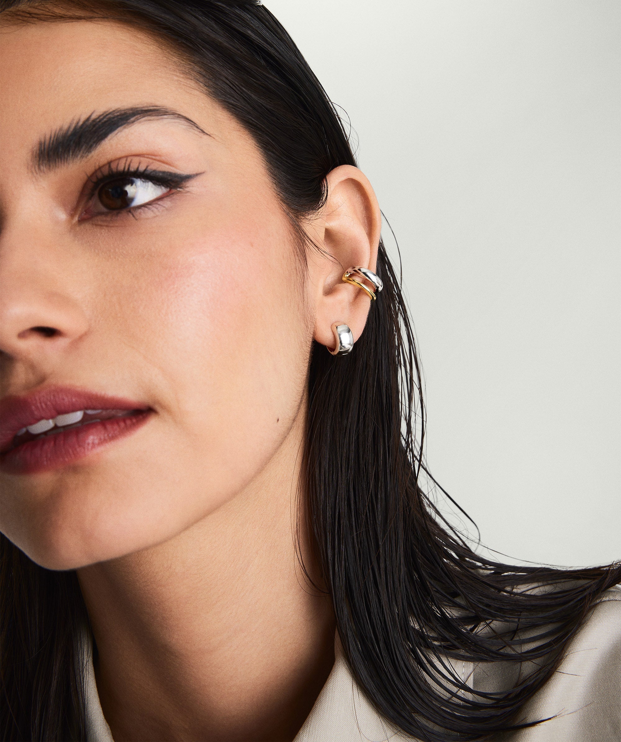 Duet Mixed Ear Cuff on a woman's ear, showcasing a blend of 18k gold vermeil and sterling silver with two distinct widths.