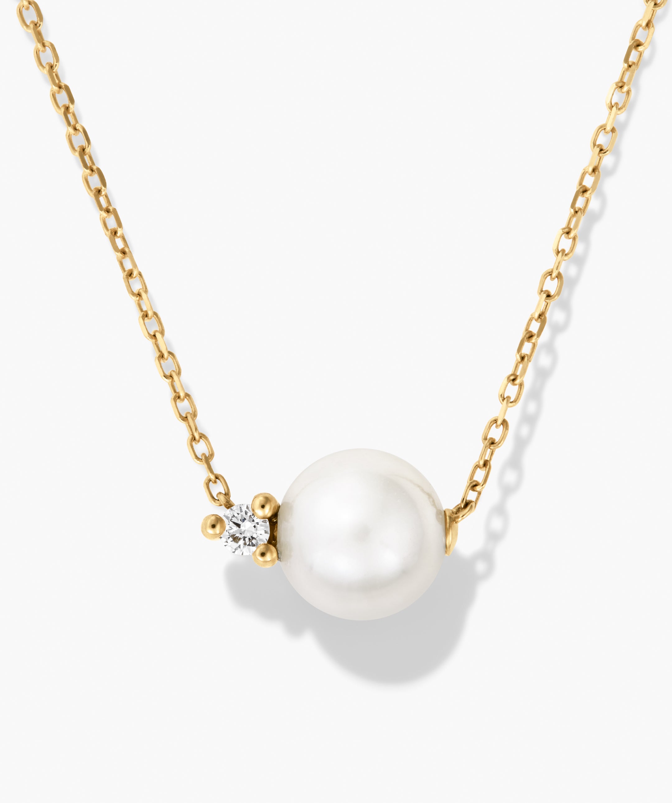 Amelie Necklace featuring a yellow-gold chain with a white freshwater pearl and a small, brilliant-cut diamond accent, showcasing elegance and refined design.