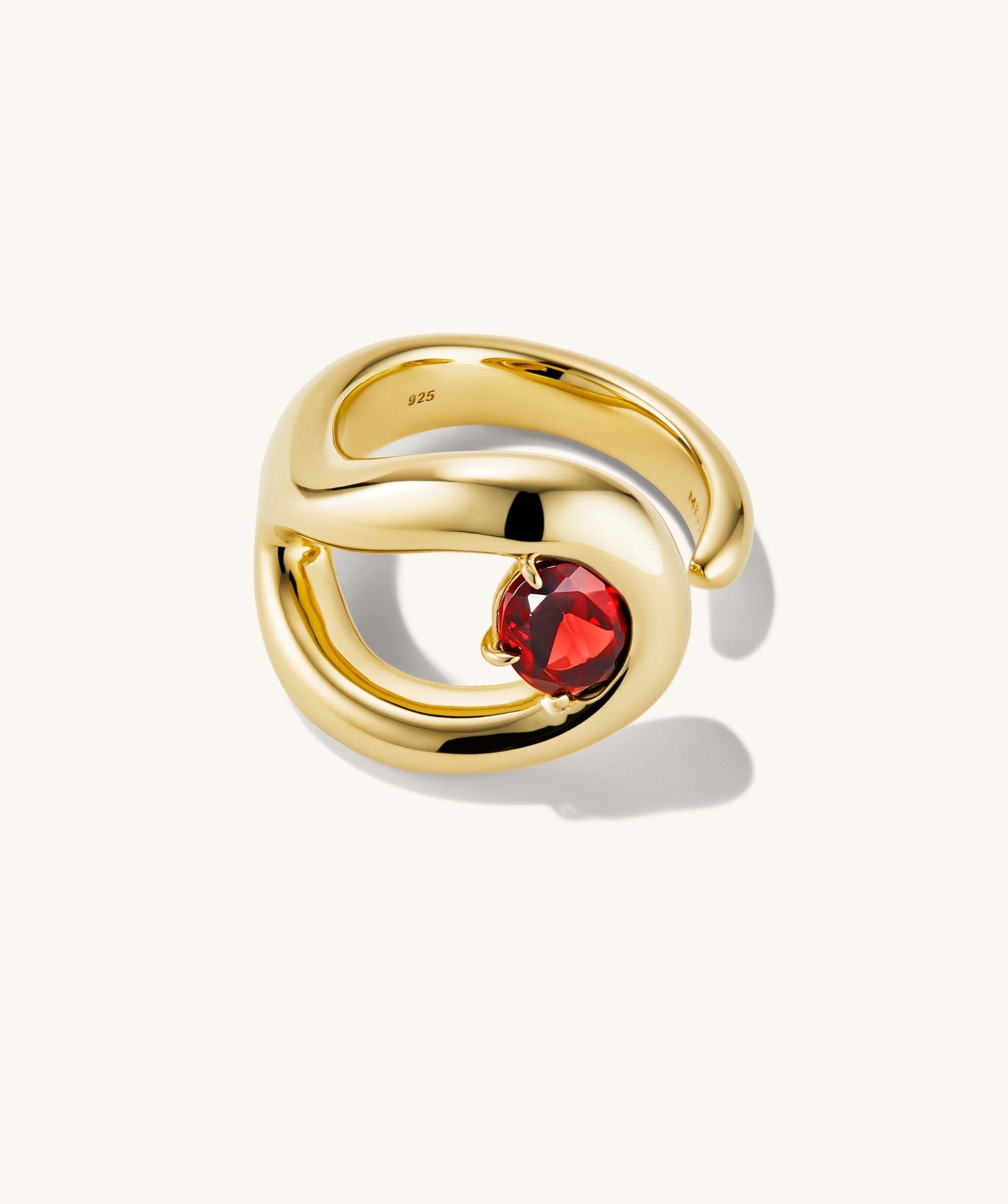 Organic DÃ´me Curve Gemstone Ring featuring a gold band with a prominent red gem, showcasing intricate curves and negative space design elements.