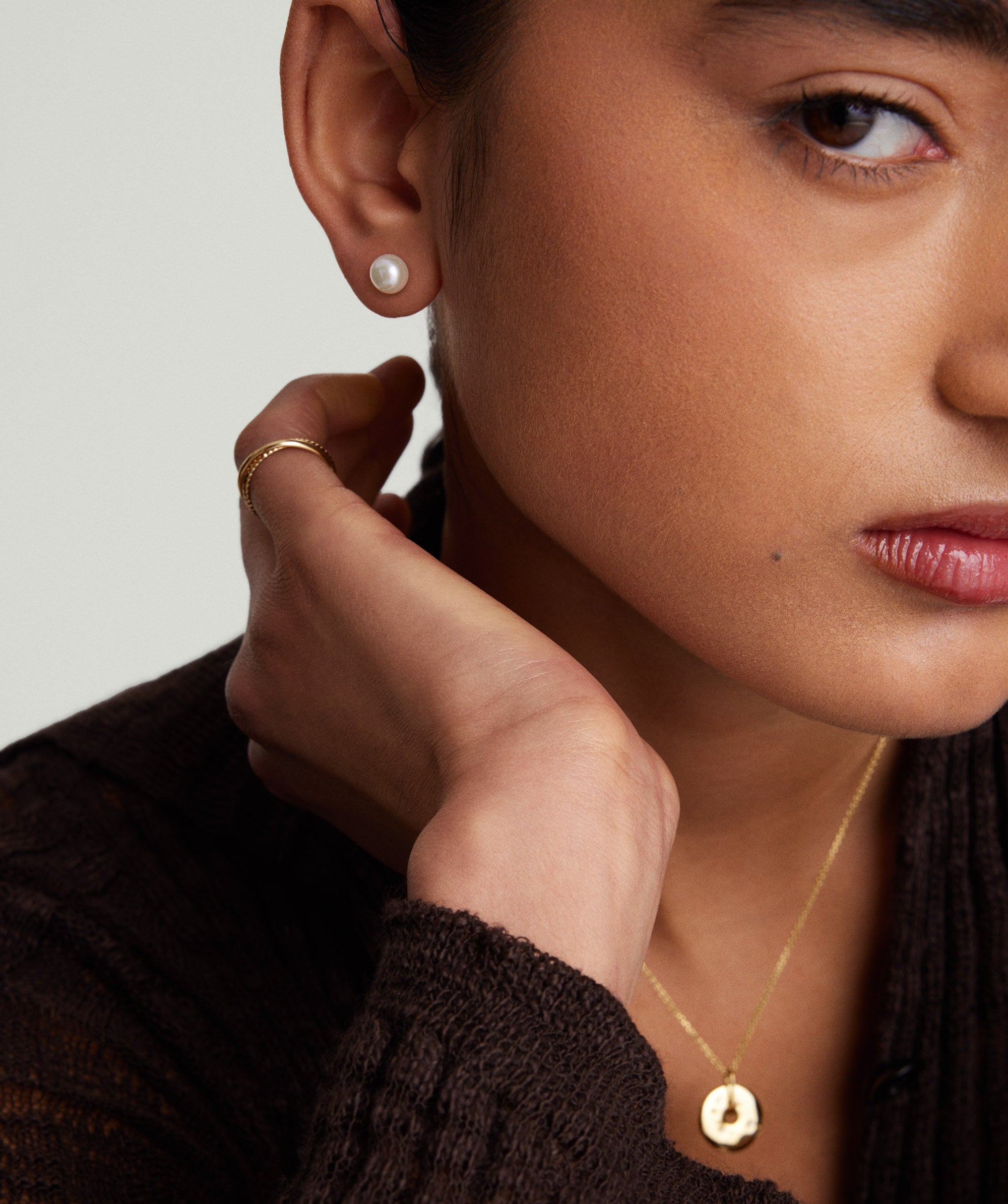Close-up of a woman showcasing Pearl Oversized Studs, handcrafted in 18k gold vermeil with freshwater pearls.