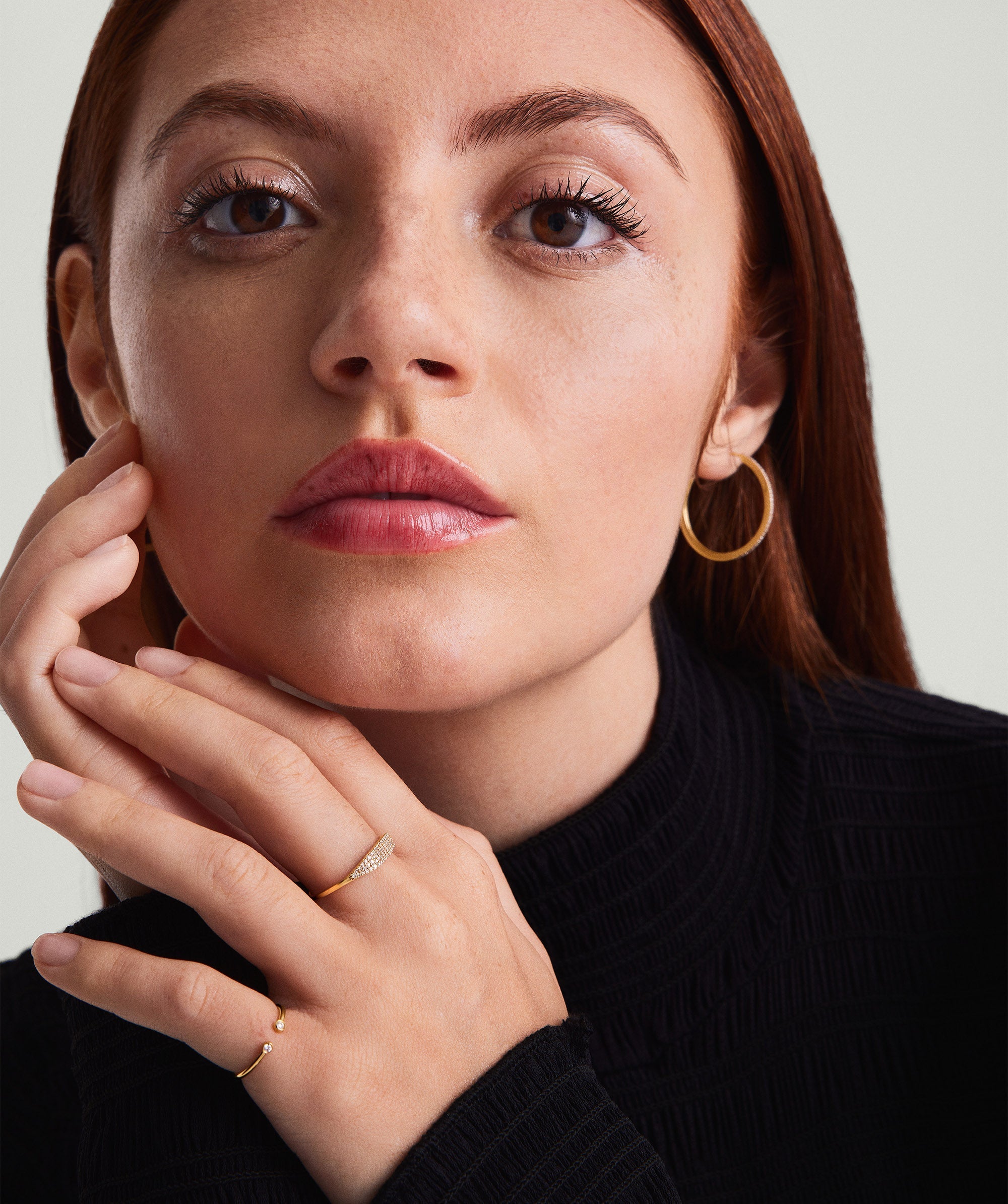 Close-up of a woman wearing the PavÃ© Diamond Slim Signet ring on her finger, highlighting the delicate diamond details and elegant design.
