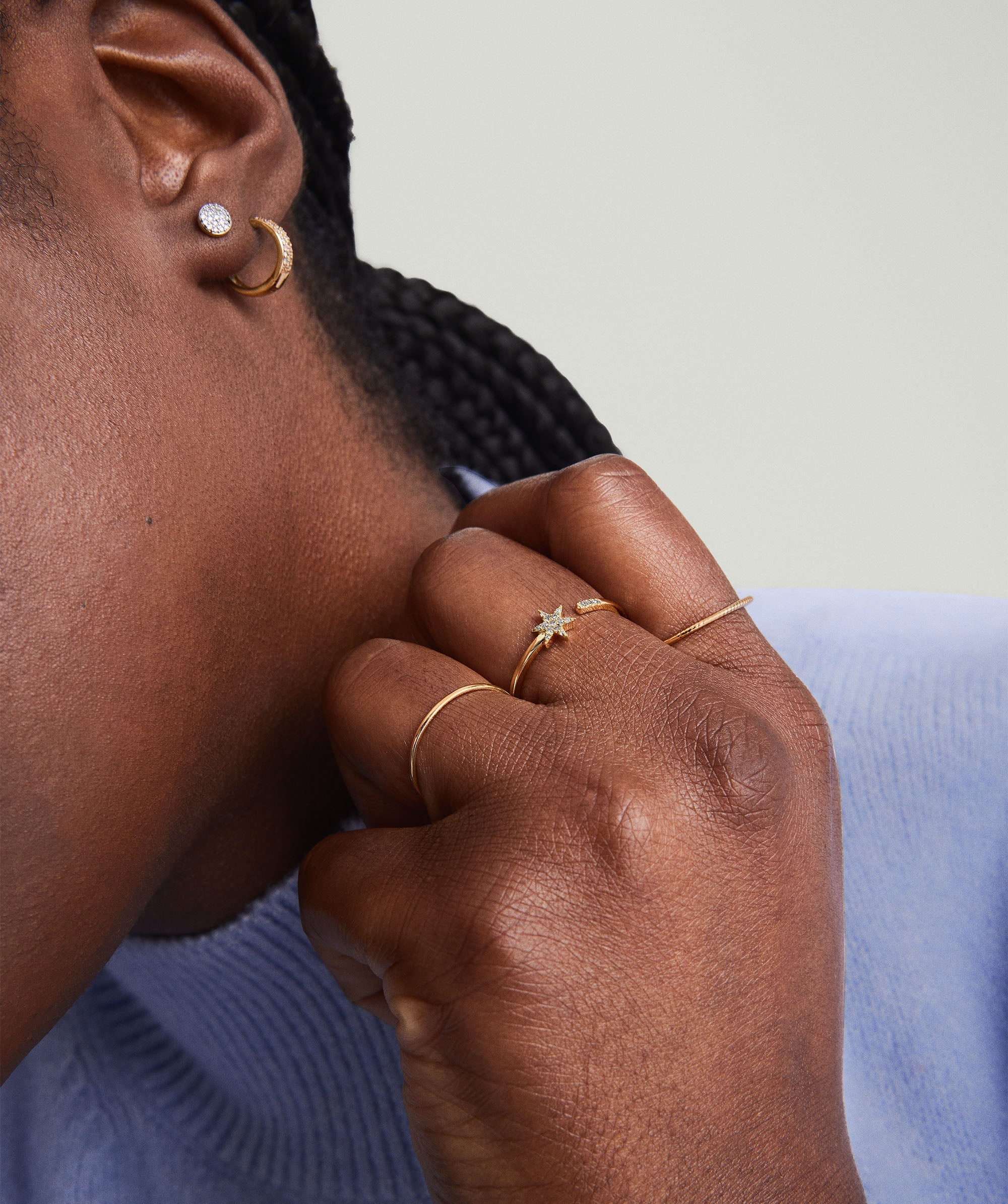 Close-up of a woman's hand wearing the PavÃ© Diamond Star Open Ring, featuring a gold star with pavÃ© diamonds.