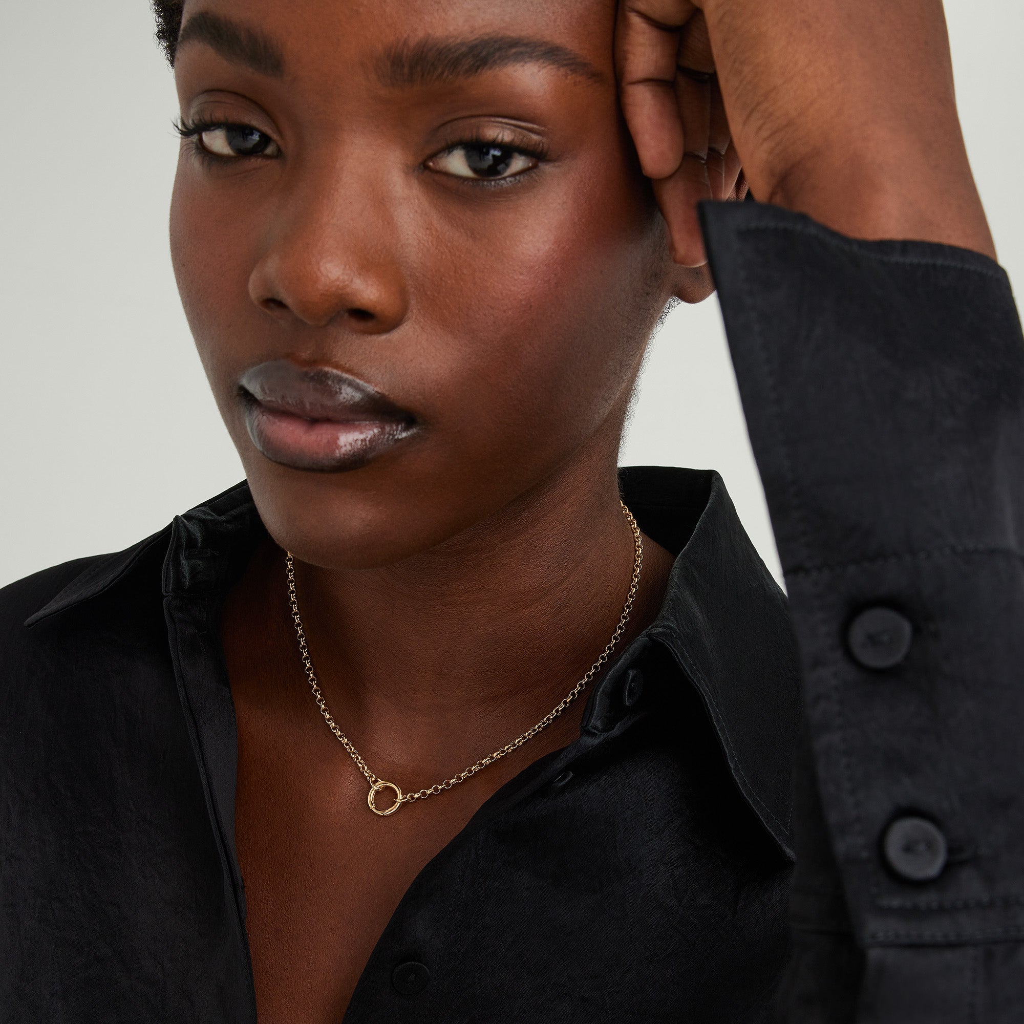 Woman wearing a black shirt and a 14k solid gold Rolo Chain Charm Necklace with Stacker Clasp, featuring three layered charms.