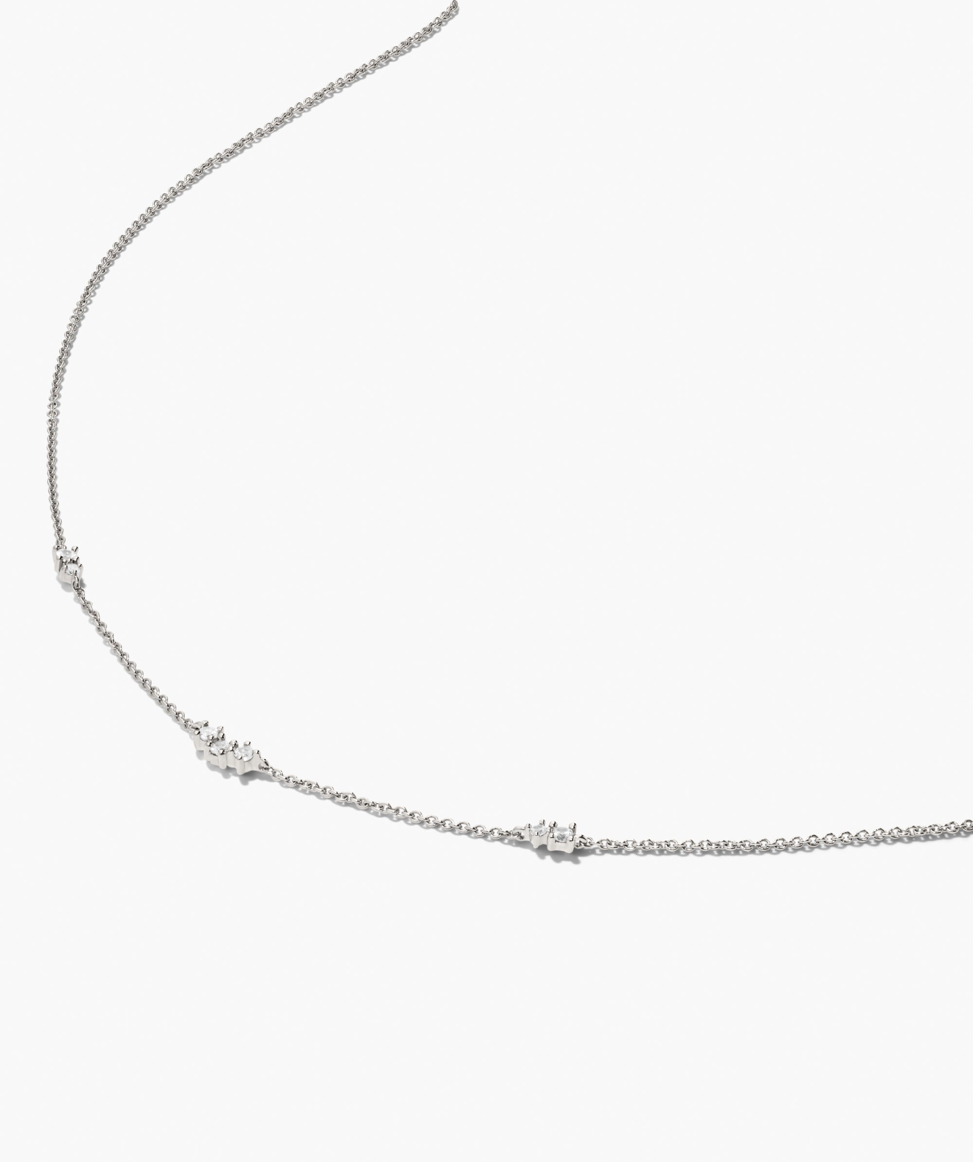 Floating Lab Grown Sapphire Necklace featuring a delicate silver chain with sparkling stones at intervals, elegantly displayed against a white background.