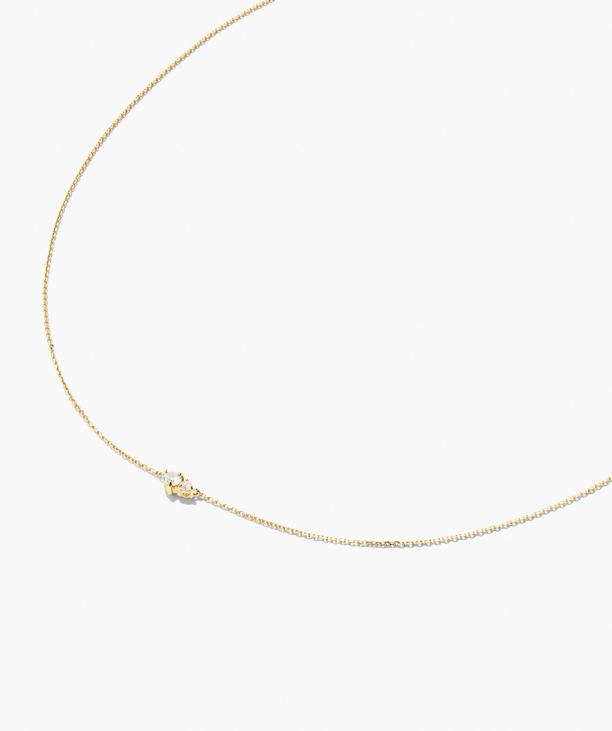 Beverly Necklace: A fine chain with a central gold charm featuring a small milky gemstone, perfect for solo wear or layering with other necklaces.