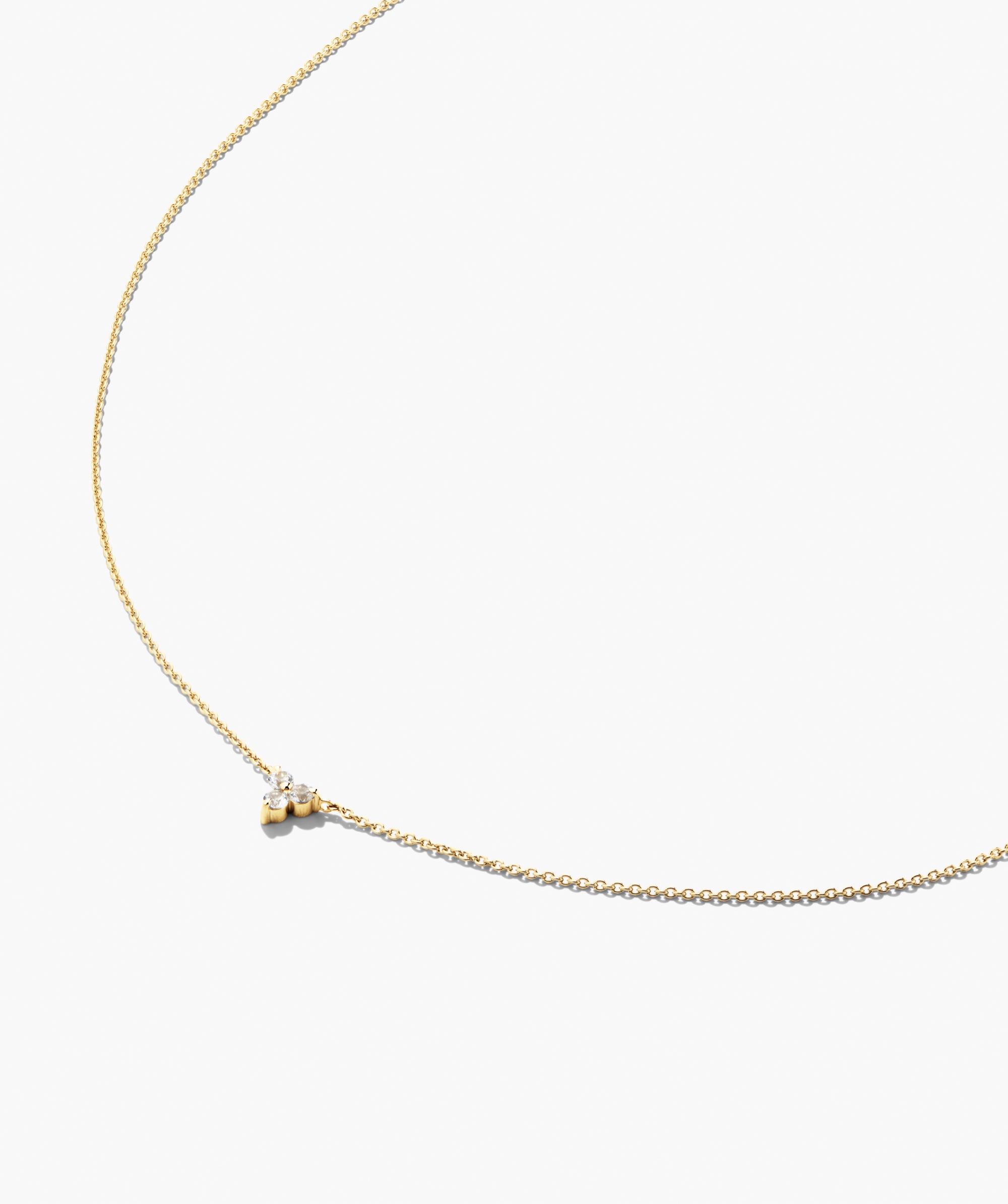 Lotus Necklace (Copy): A minimalist yellow-gold chain featuring a small, off-center pendant with three clear stones, offering versatile elegance for any occasion.