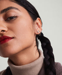 Single Bar Chain Stud: Close-up of a woman's ear showcasing a 14k gold stud earring with a chain detail, designed for versatile wear in ear piercings.