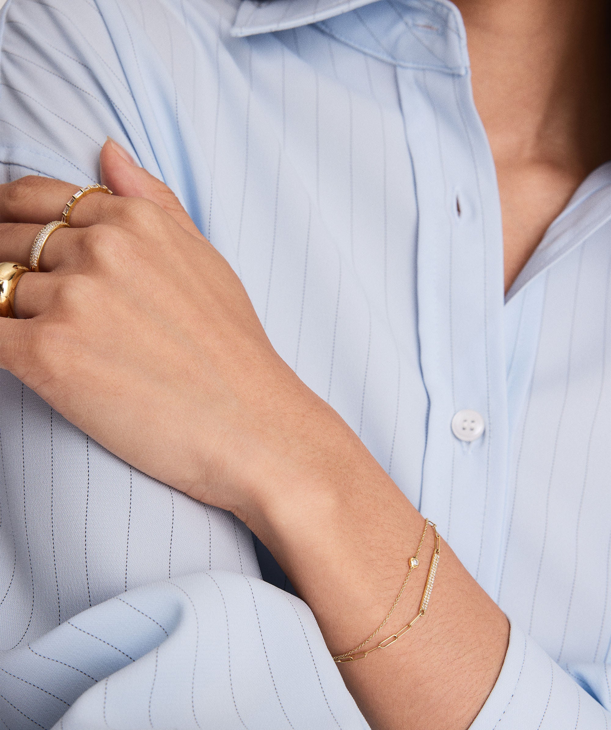 Solo Diamond Bracelet on a woman's wrist, featuring a solid gold band and a round cut diamond in a bezel setting.