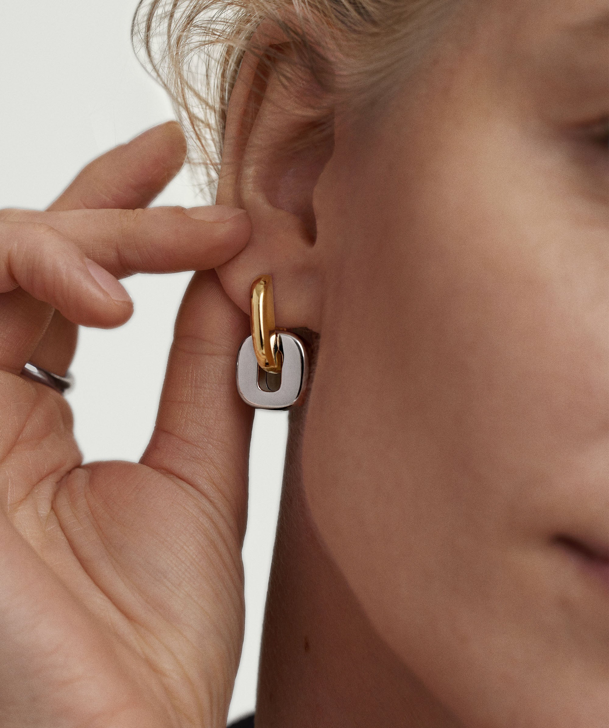 Close-up of a woman's ear wearing Stevie Hoop Links, showcasing the elegant, interchangeable, and reversible design for versatile styling options.