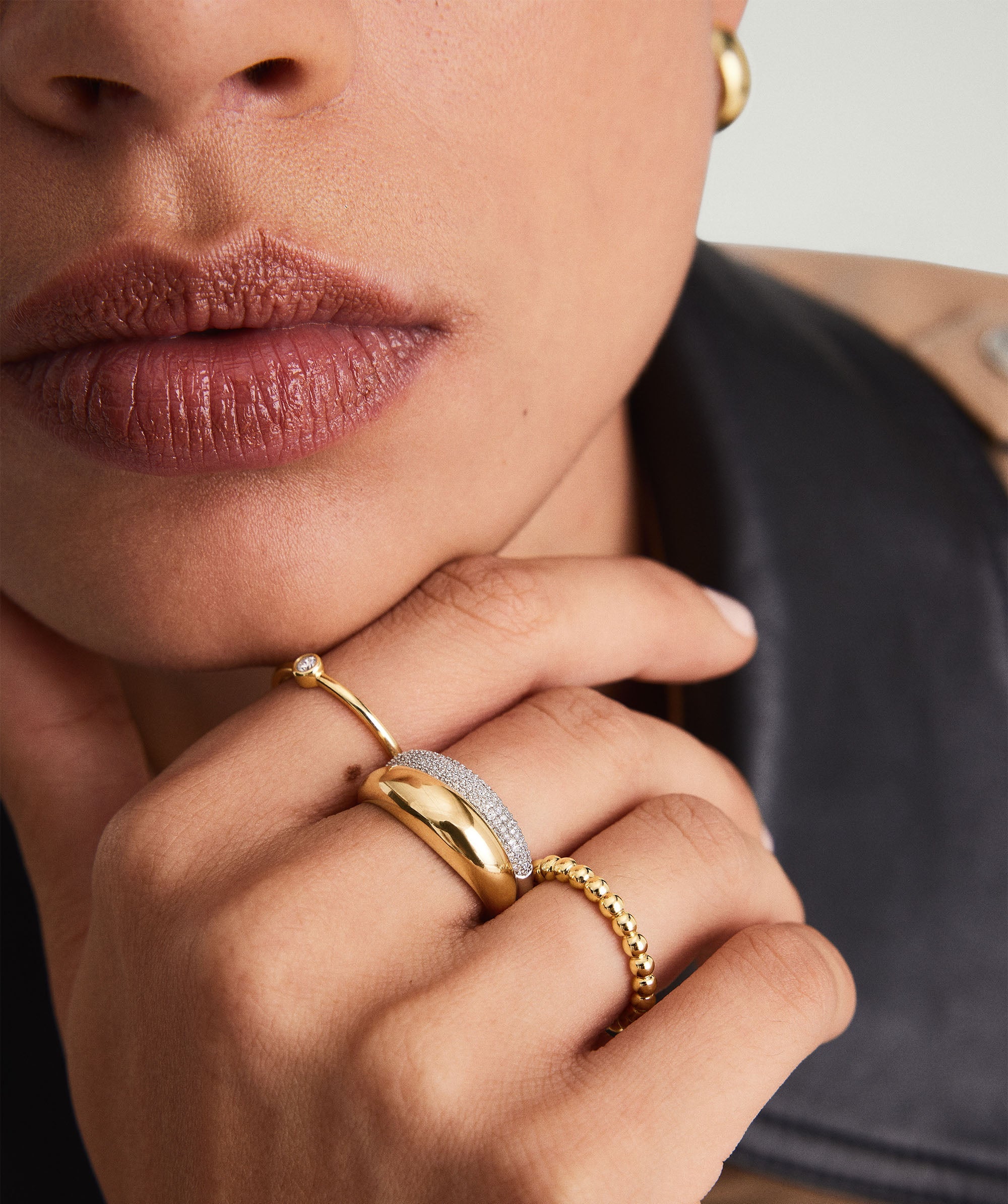 Close-up of a woman's hand wearing the Thin DÃ´me Ring, a 14k solid gold, ultra-light, bold design ring.