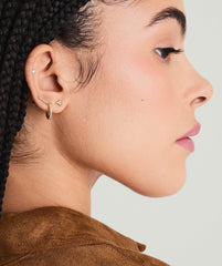 Profile of a woman wearing a Mini Lotus Diamond Stud earring, showcasing the lotus-shaped diamond in 14k solid gold.