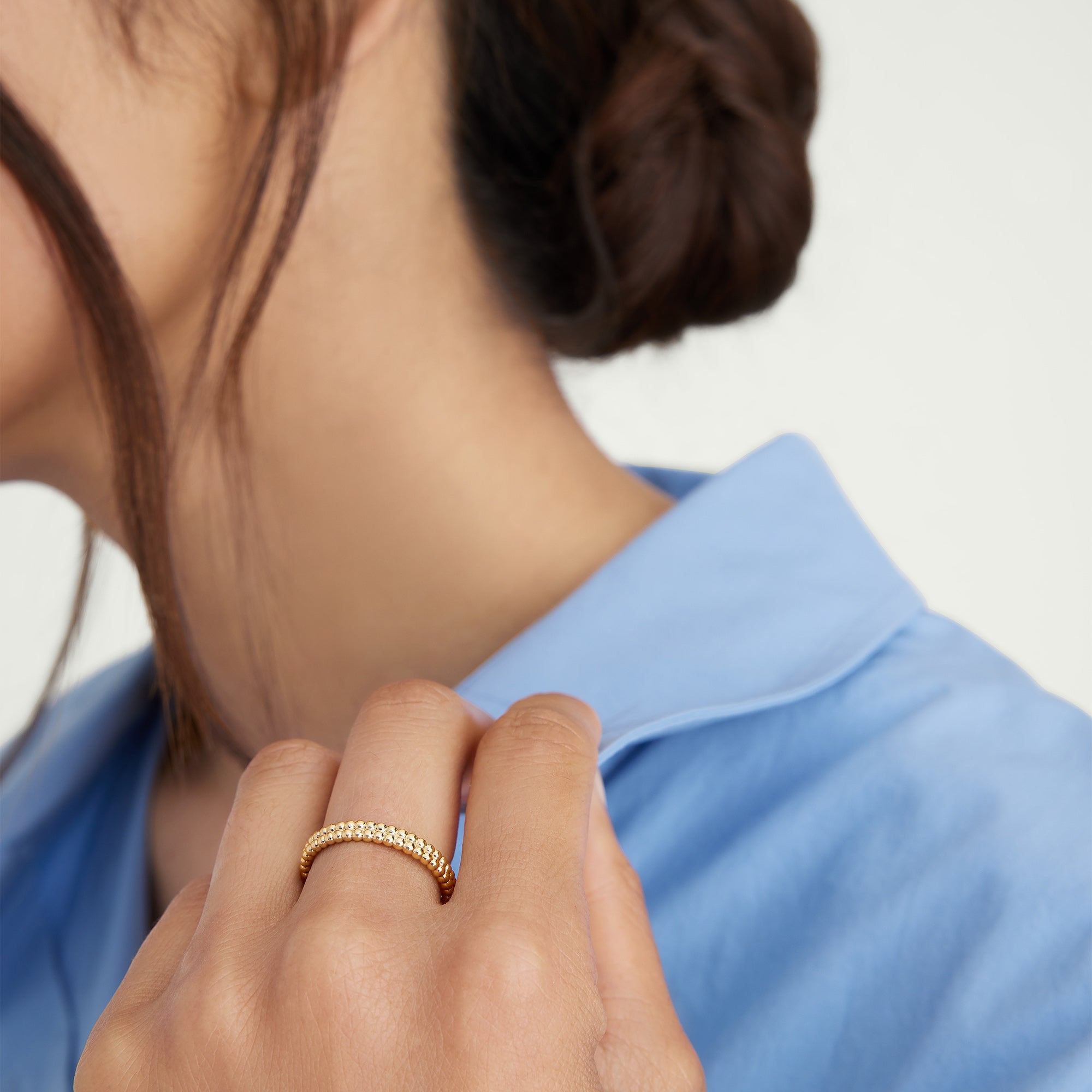 Close-up of a woman's hand wearing the Duo Beaded Stacker Ring, showcasing its intricate beaded design in 18k gold vermeil.