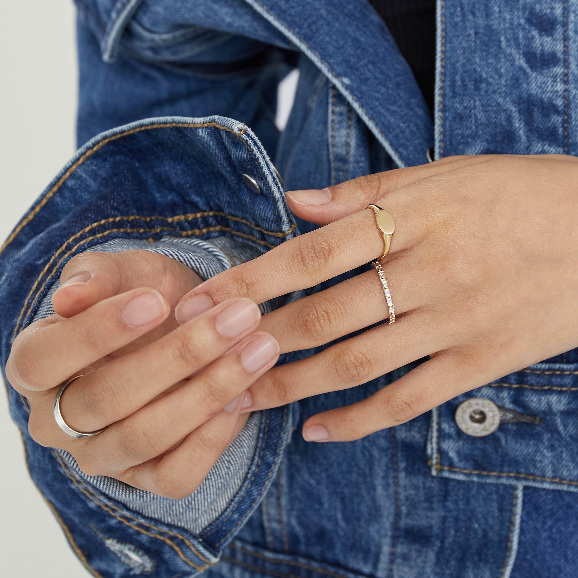 Close-up of a hand wearing a 14k solid gold Baguette Diamond Eternity Band with Kimberley Process-certified diamonds.