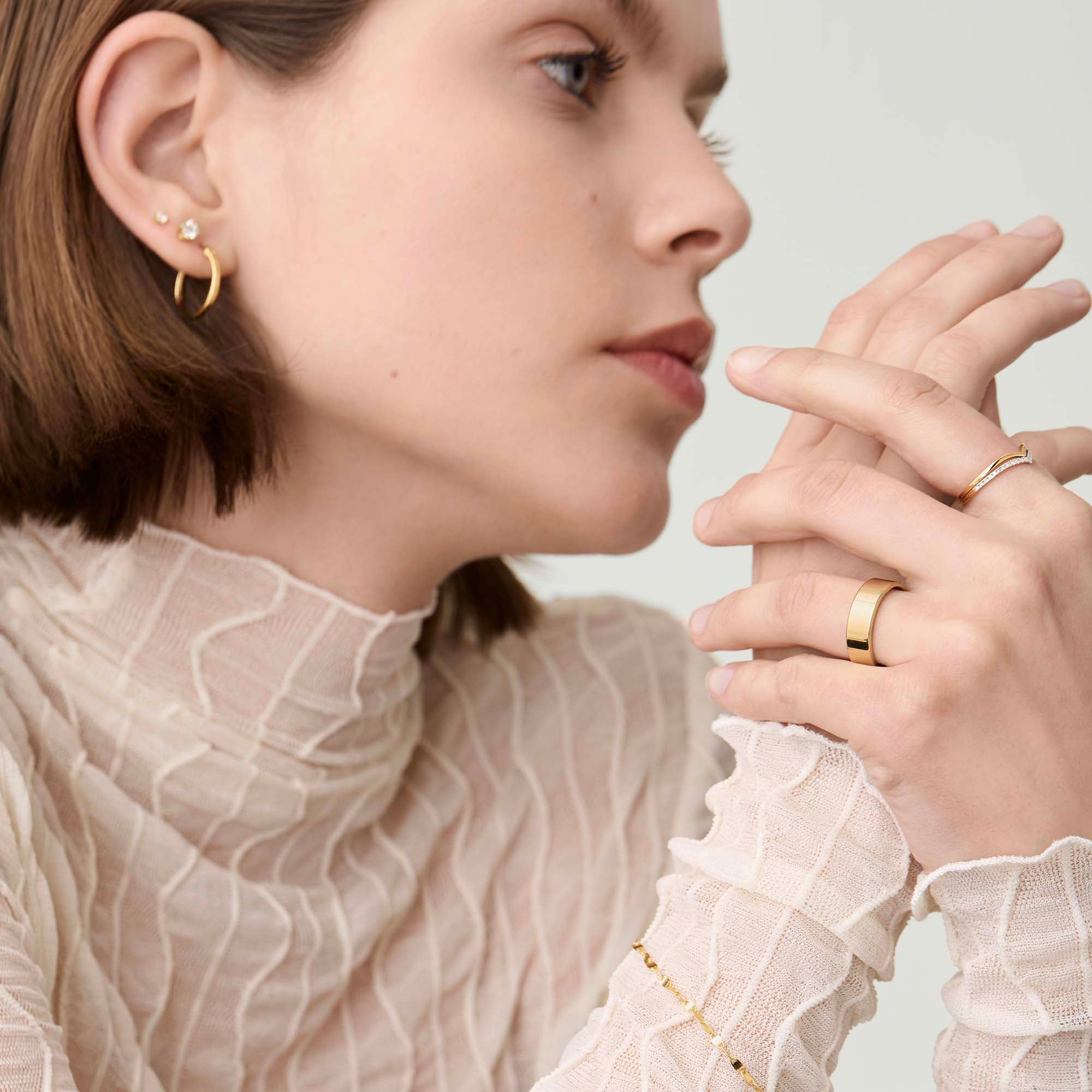 A woman displays a 6mm Smooth Band on her hand, emphasizing the ring's sleek design and elegant appearance.