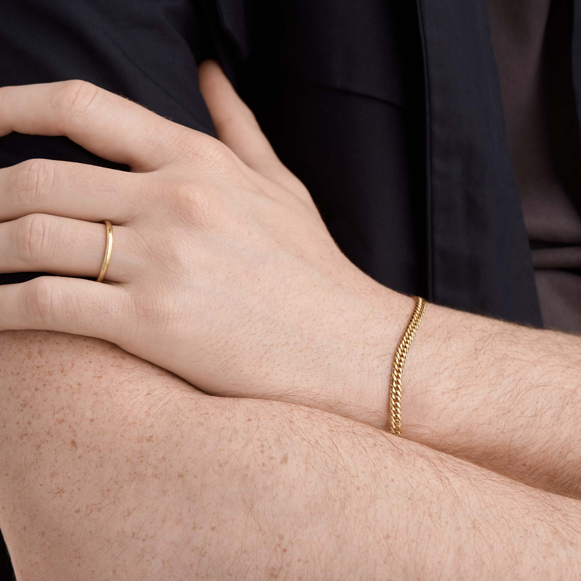 Person wearing the 2mm Smooth Band, a handcrafted 14k solid gold ring with streamlined edges, symbolizing an enduring bond.