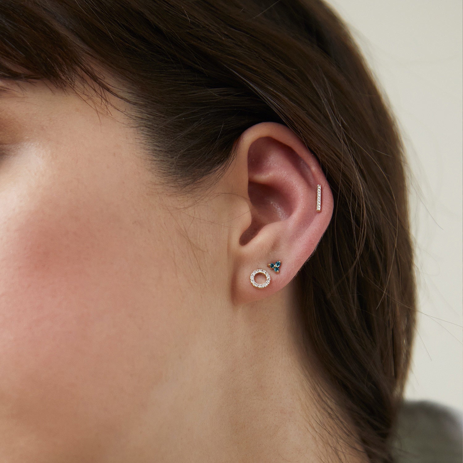 Close-up of a woman's ear wearing a Single PavÃ© Diamonds Long Bar Stud, handcrafted in 14k solid gold and set with diamonds.