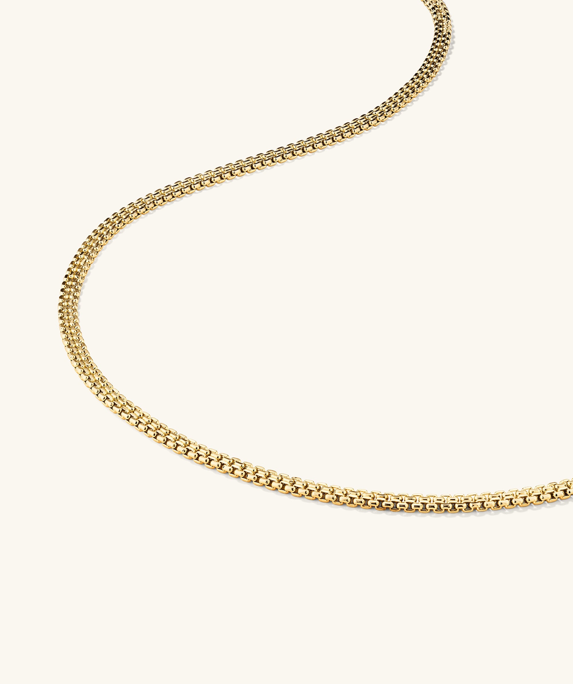 Timepiece Chain Necklace: Close-up of a 14k gold handcrafted chain, displayed on a white surface.