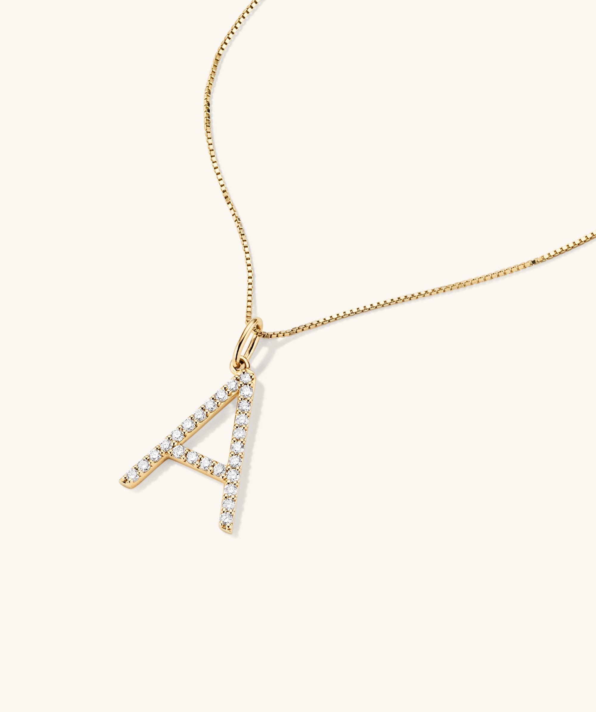 Gold necklace featuring a handcrafted 14k gold oversized letter charm adorned with lab-grown diamonds, emphasizing ethical and responsible production.