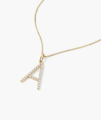 Gold necklace featuring a handcrafted 14k gold oversized letter charm adorned with lab-grown diamonds, emphasizing ethical and responsible production.