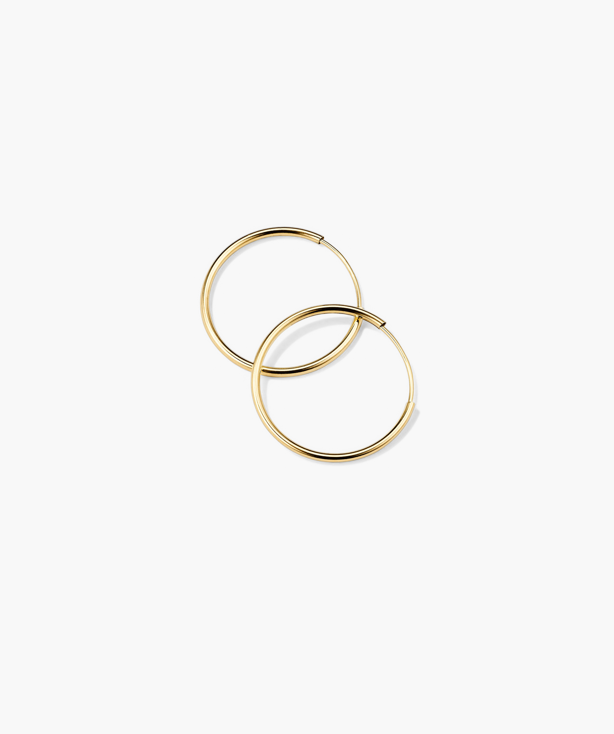 Between Hoops: Handcrafted 14k gold hoop earrings, lightweight and suitable for daily wear, including swimming.