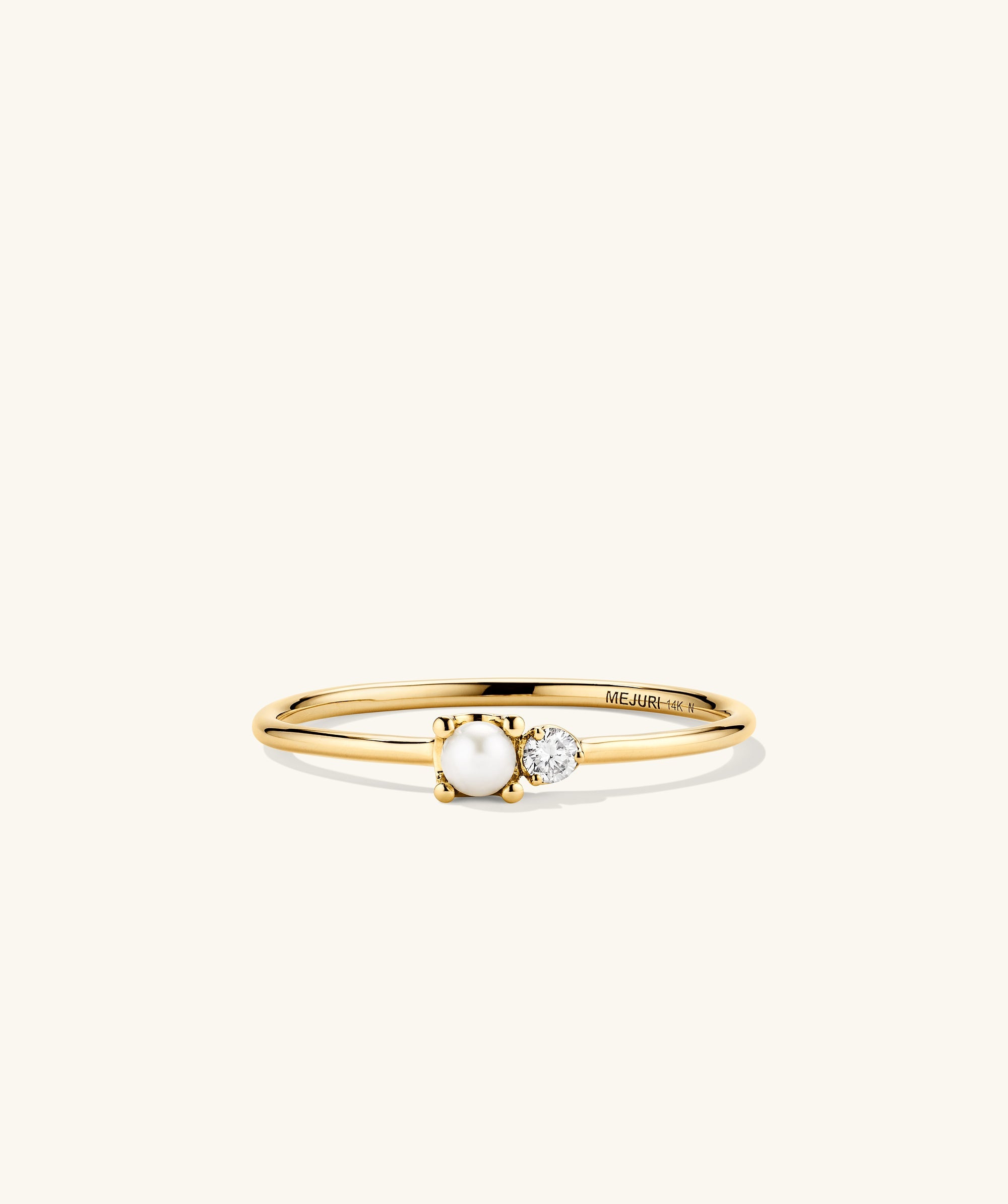 Pearl and Diamond Stacker Ring: A close-up of a 14k gold ring featuring a central freshwater pearl and two side diamonds.