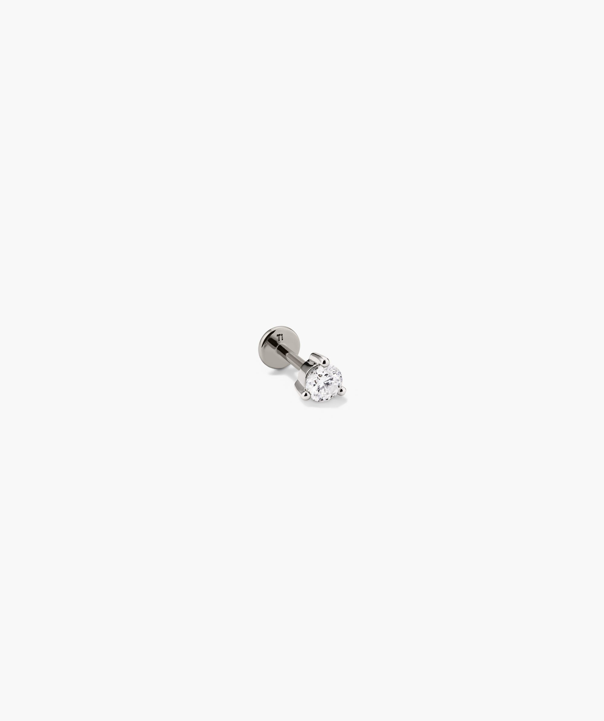 Close-up of Piercing Studio's Round Diamond Flat Back Stud, featuring a simple diamond set in metal, ideal for stacking.