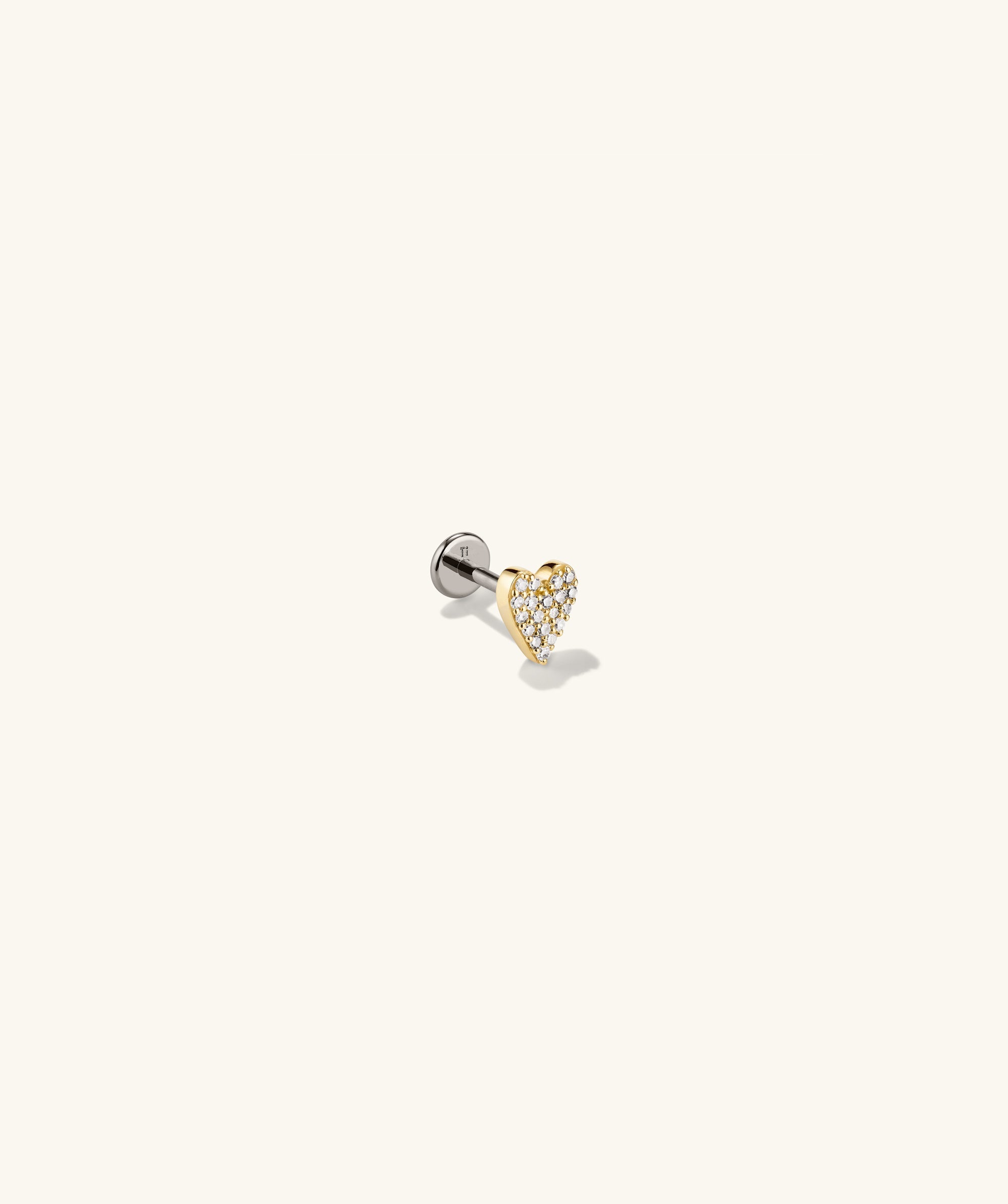 Close-up of the Piercing Studio - PavÃ© Diamond Heart Flat Back Stud, showcasing a heart-shaped design with diamonds, blending gold and silver elements for a playful statement piece.