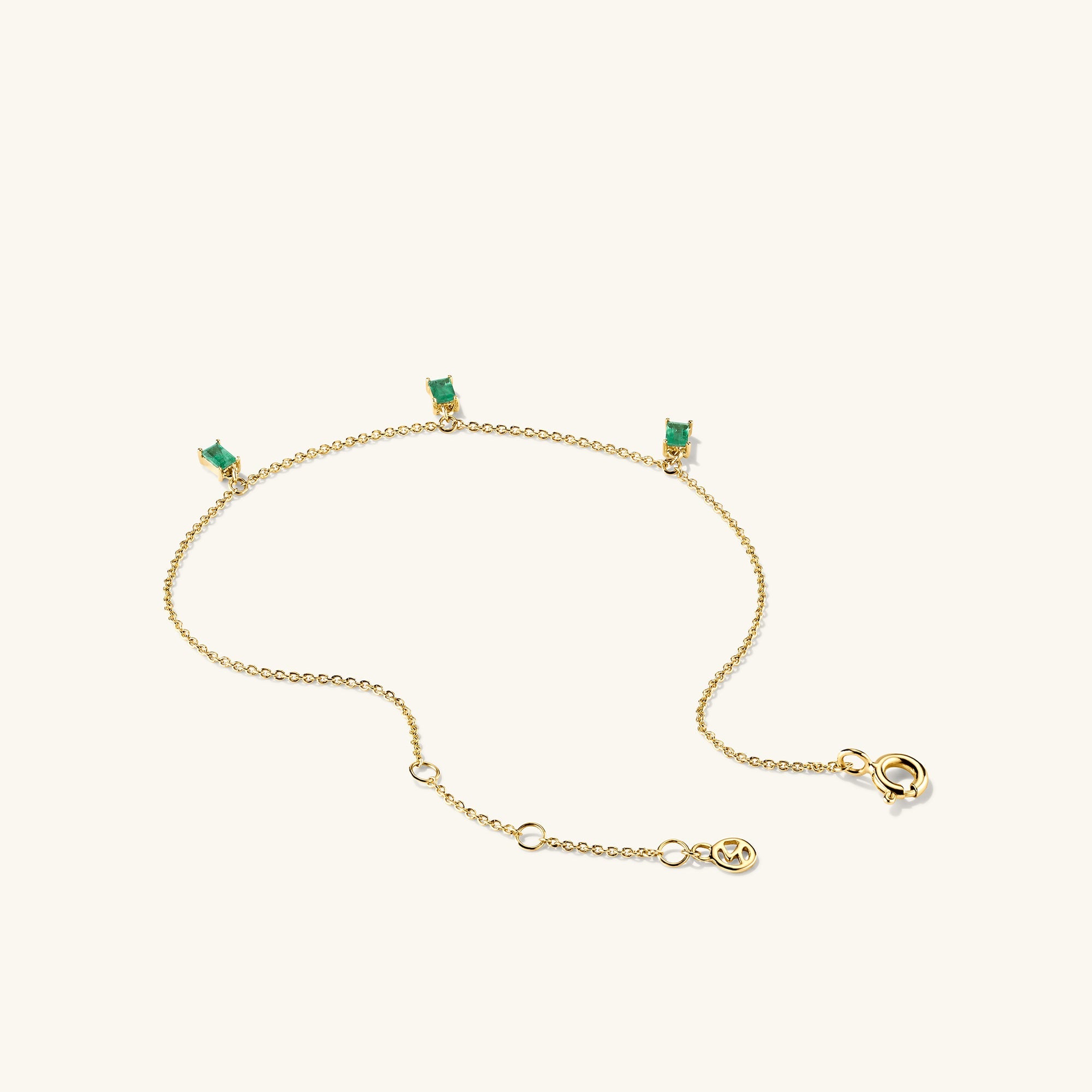 Baguette Gemstone Bracelet: A gold chain adorned with green stones, designed for stacking and enhancing your jewelry collection.
