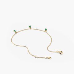 Baguette Gemstone Bracelet: A gold chain adorned with green stones, designed for stacking and enhancing your jewelry collection.