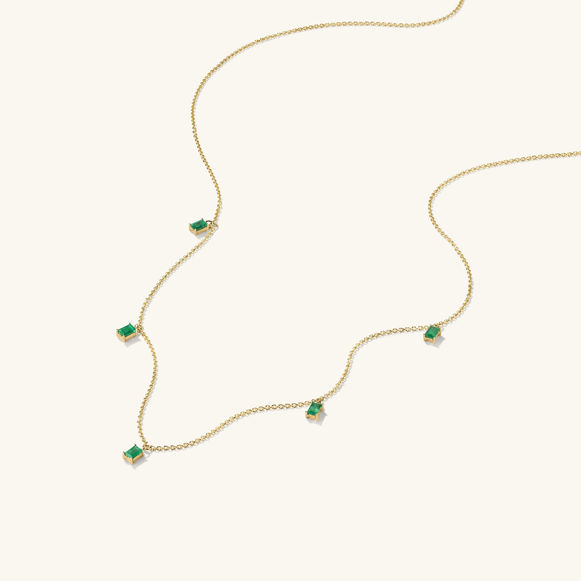 Baguette Gemstone Station Necklace featuring a gold chain adorned with green stones, perfect for creating standout jewelry stacks.