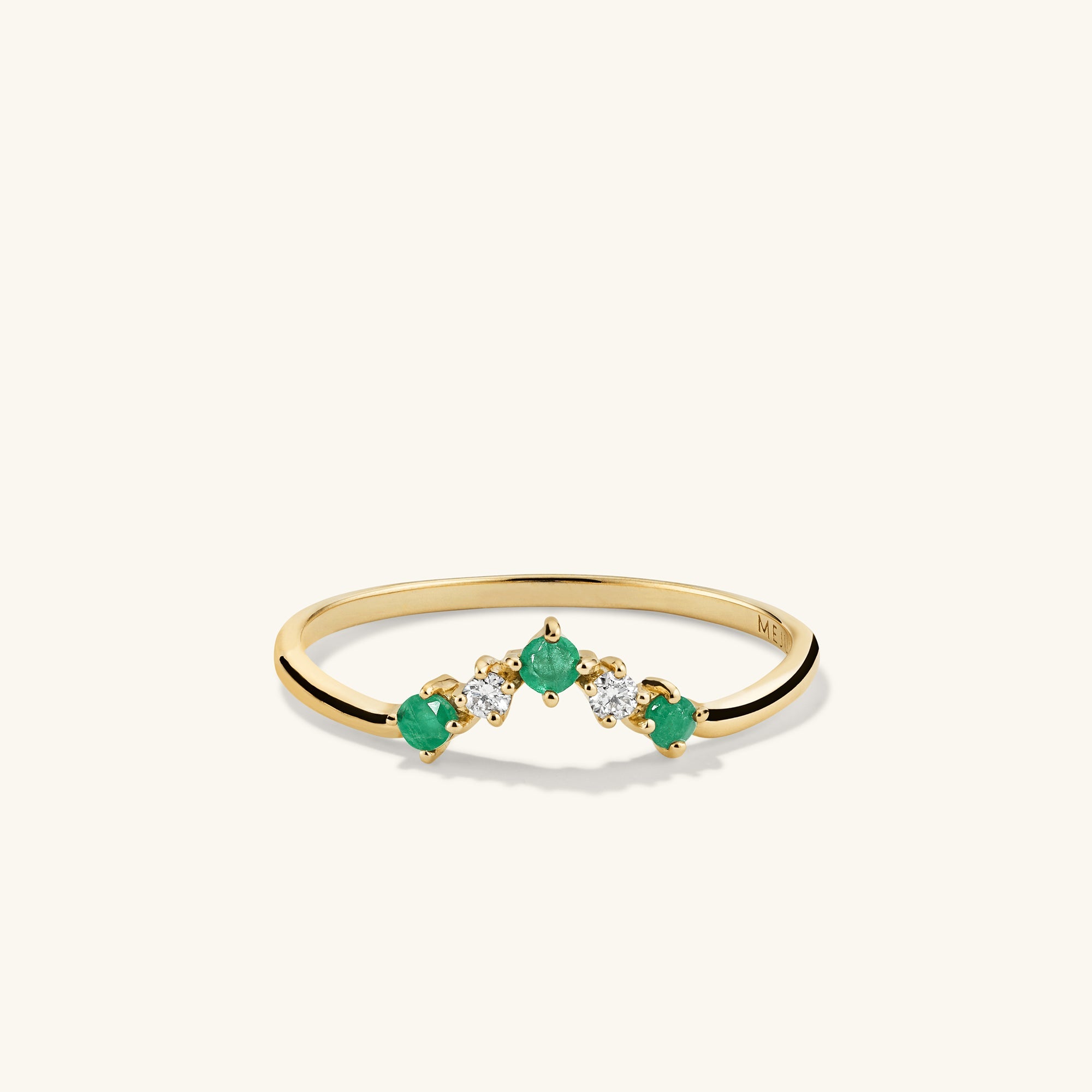Emerald and Diamond Wishbone Ring: 14k gold ring with three stones, featuring emerald gemstones and responsibly sourced diamonds, showcased in a close-up view.