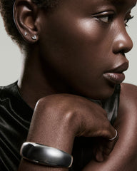 Profile of a woman wearing Piercing Studio - Lab Grown Diamond Marquise Studs, showcasing elegant studs alongside a sleek metal bangle and thin band ring.