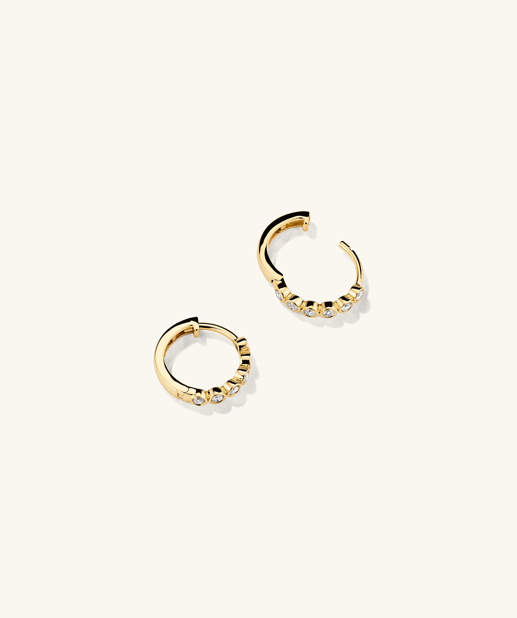 Bezel Lab Grown Diamond Huggies: A pair of 14k solid gold hoop earrings featuring bezel-set lab grown diamonds.