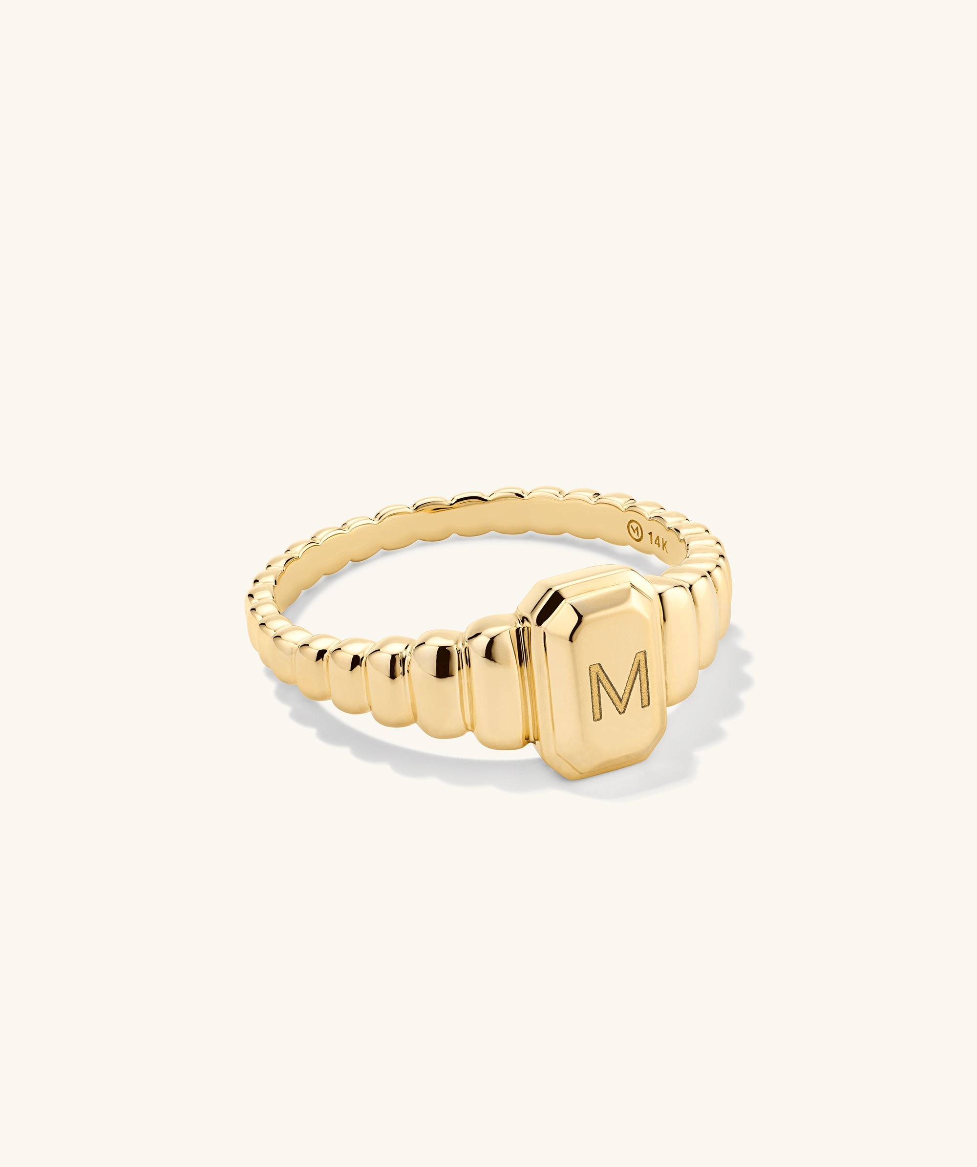Charlotte Step Cut Signet Ring featuring a letter engraving on gold, designed as an engravable statement accessory enhancing any outfit with its textured elegance.