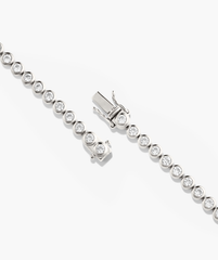 Zadie Bezel Lab Grown Sapphire Tennis Necklace featuring a silver chain adorned with sparkling lab-grown sapphires in a bezel setting, showcasing luxury and elegance.