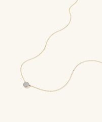 Large PavÃ© Diamond Round Necklace: a close-up of a 14k gold chain featuring a diamond pendant adorned with pavÃ©-set diamonds.