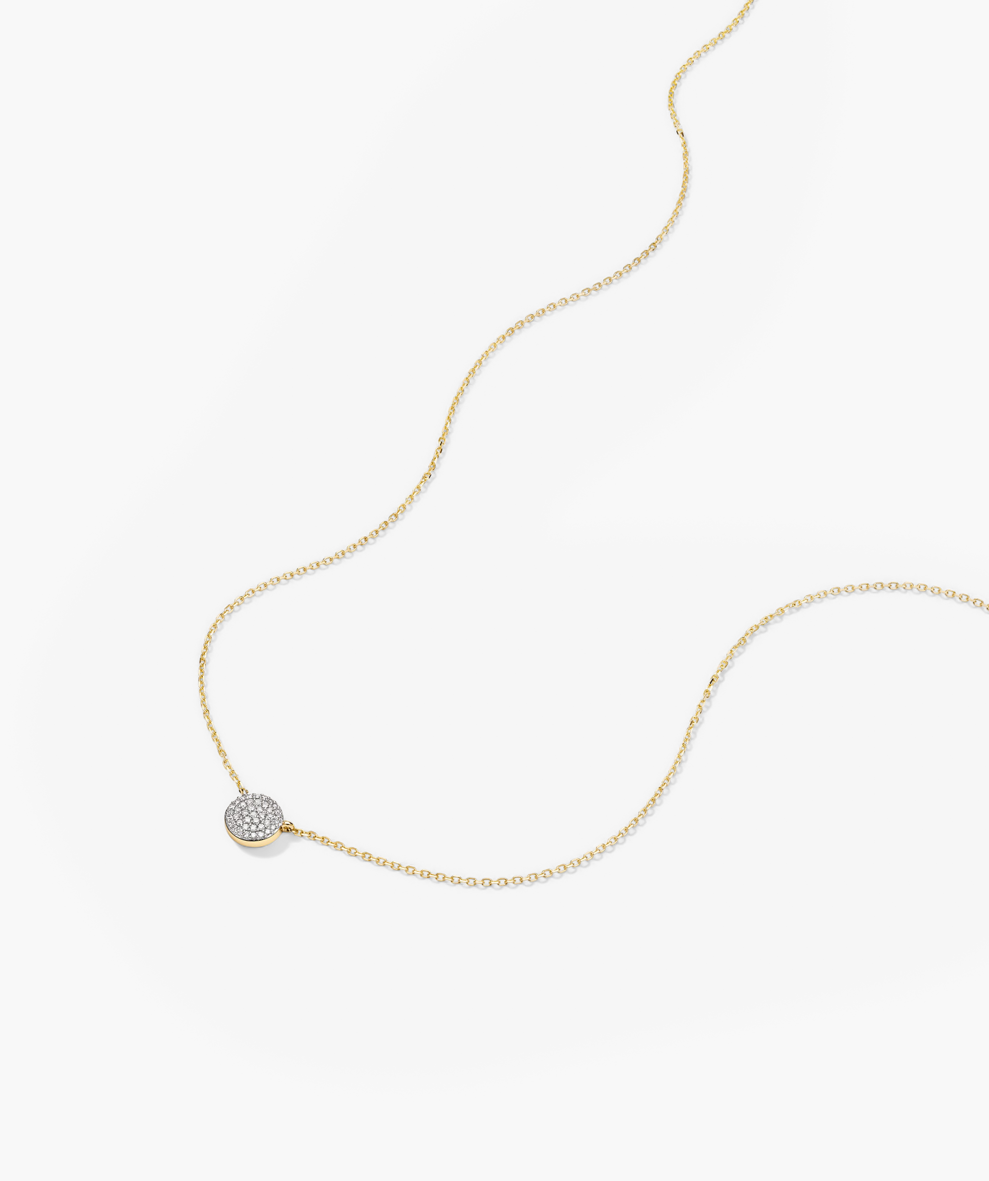 Large PavÃ© Diamond Round Necklace: a close-up of a 14k gold chain featuring a diamond pendant adorned with pavÃ©-set diamonds.