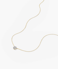 Large PavÃ© Diamond Round Necklace: a close-up of a 14k gold chain featuring a diamond pendant adorned with pavÃ©-set diamonds.