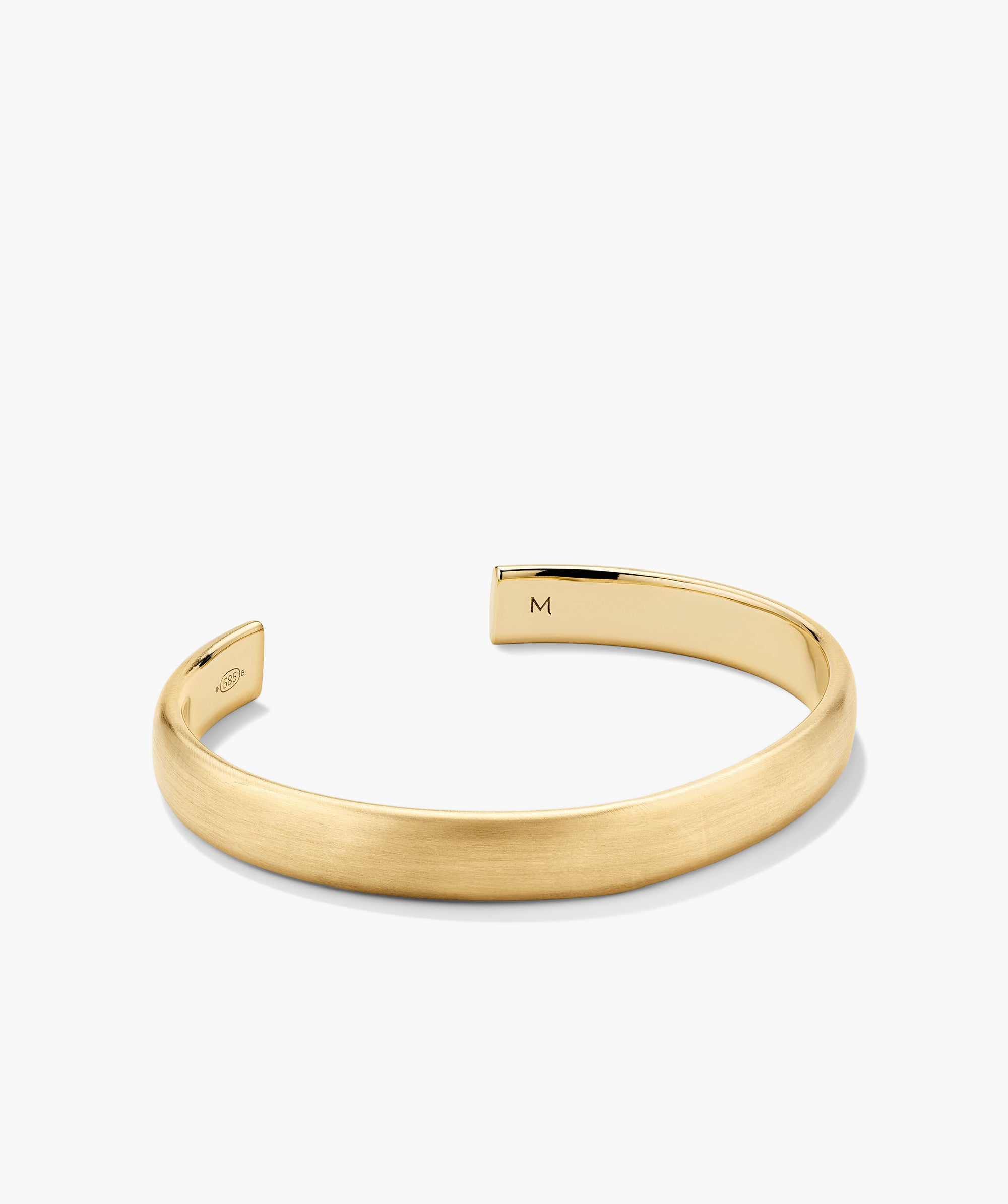 Bold Cuff: A gold bracelet with a simple yet bold silhouette, featuring a letter M charm.