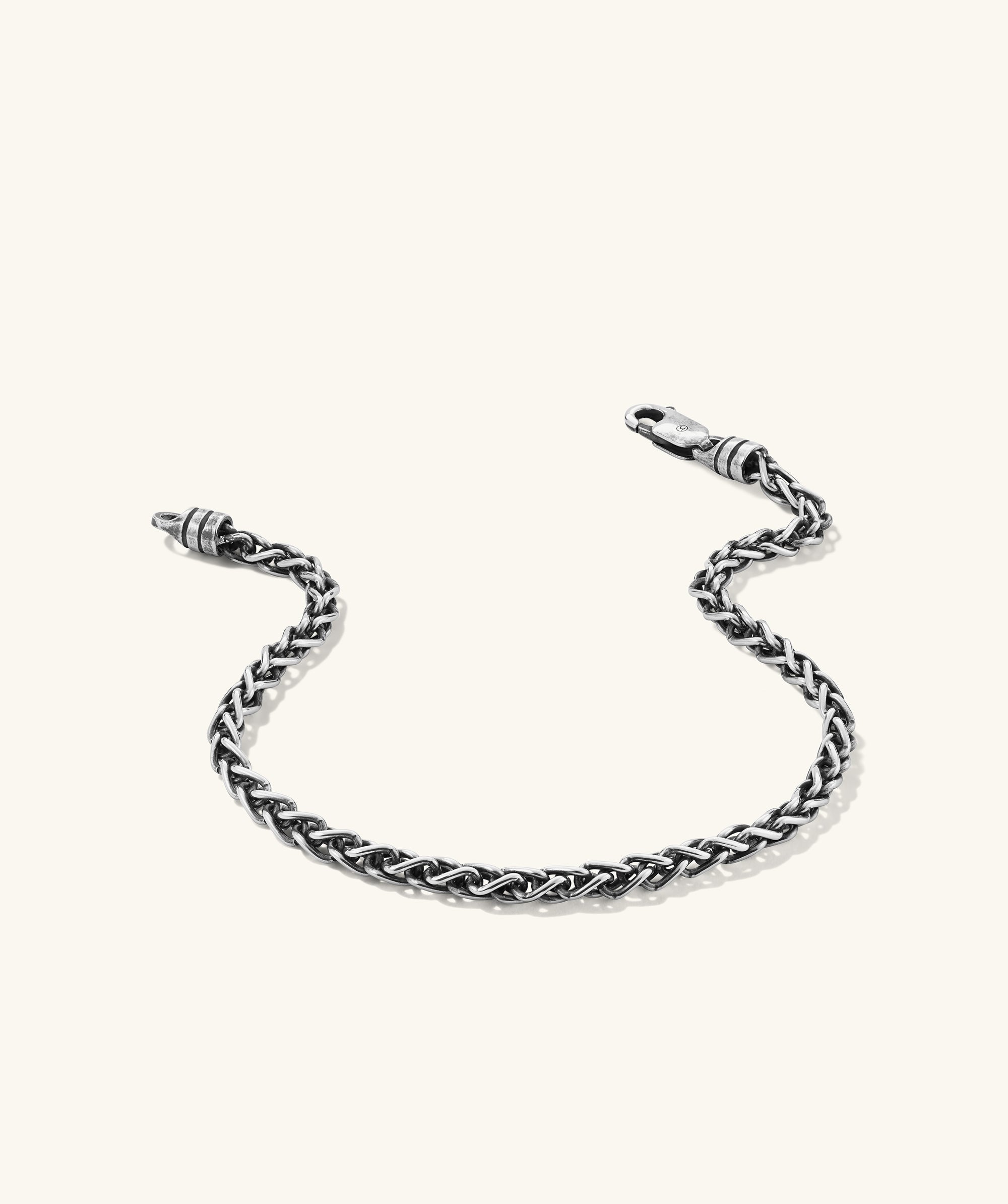 3.3mm Wheat Chain Bracelet: A close-up of an intricately-woven wheat chain bracelet with a clasp, handcrafted in oxidized sterling silver for a lived-in look.